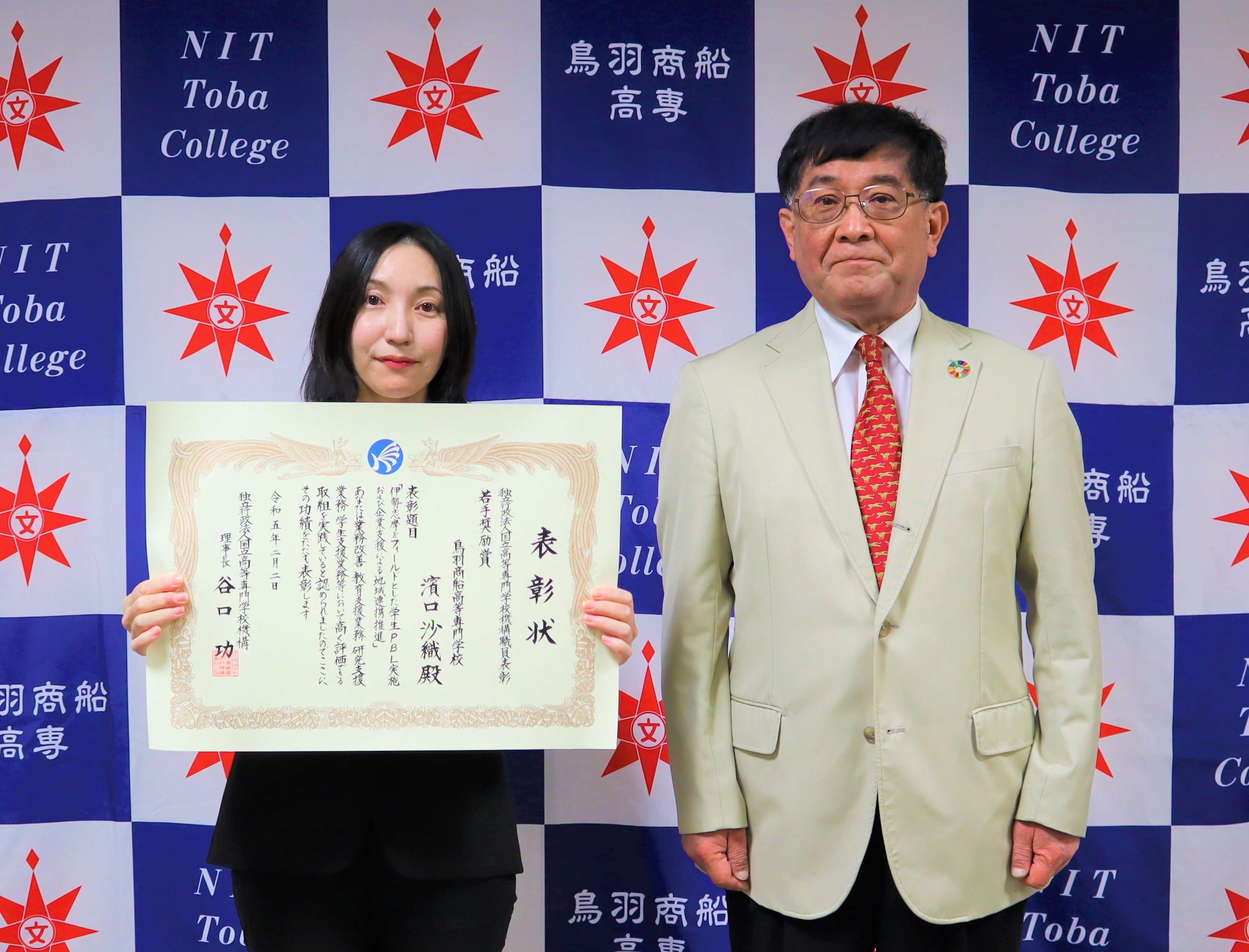 学内での受賞報告の様子（左：濱口技術専門職員、右：和泉校長）