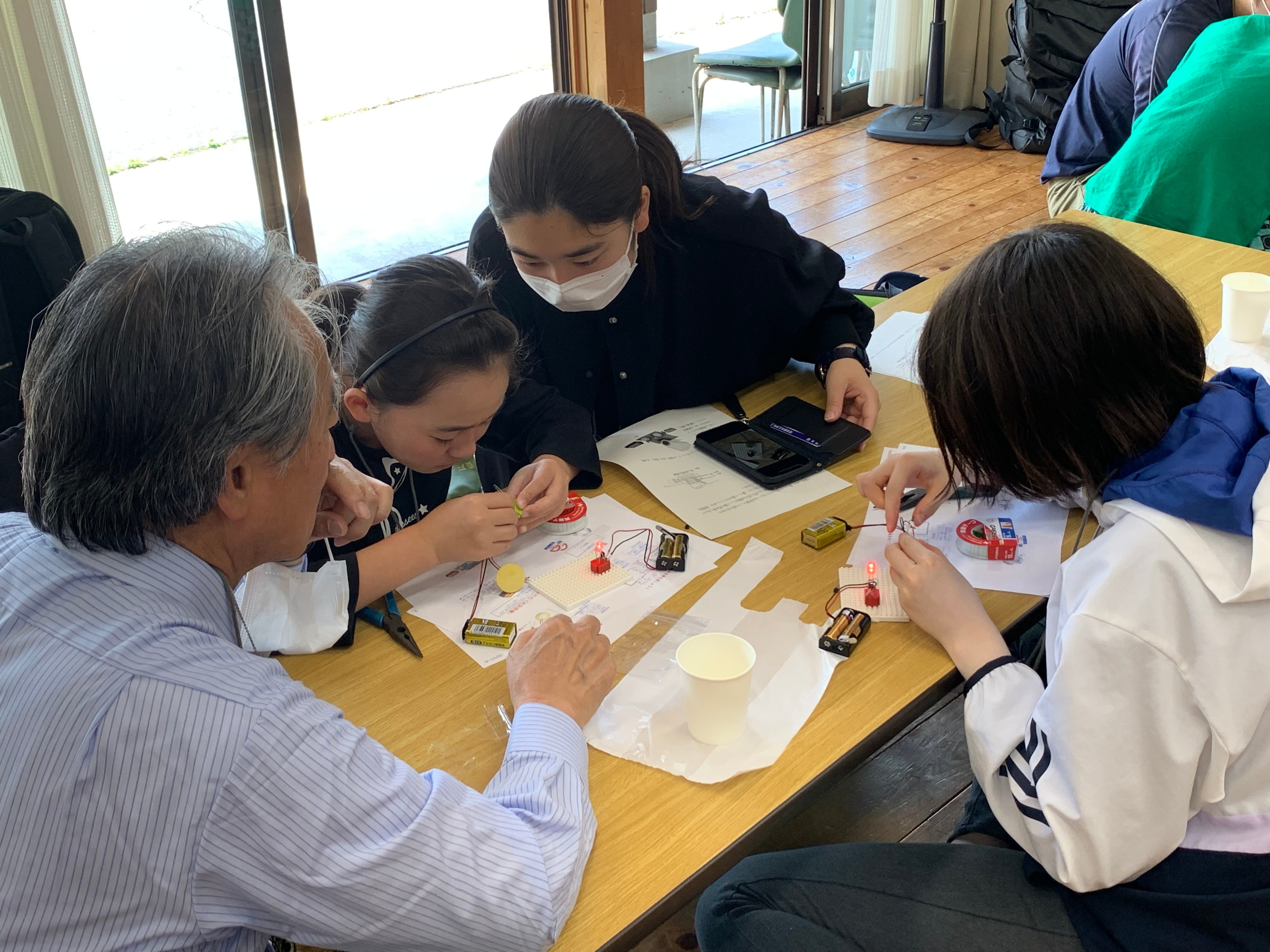 小学生と一緒に科学工作に取り組む高専生