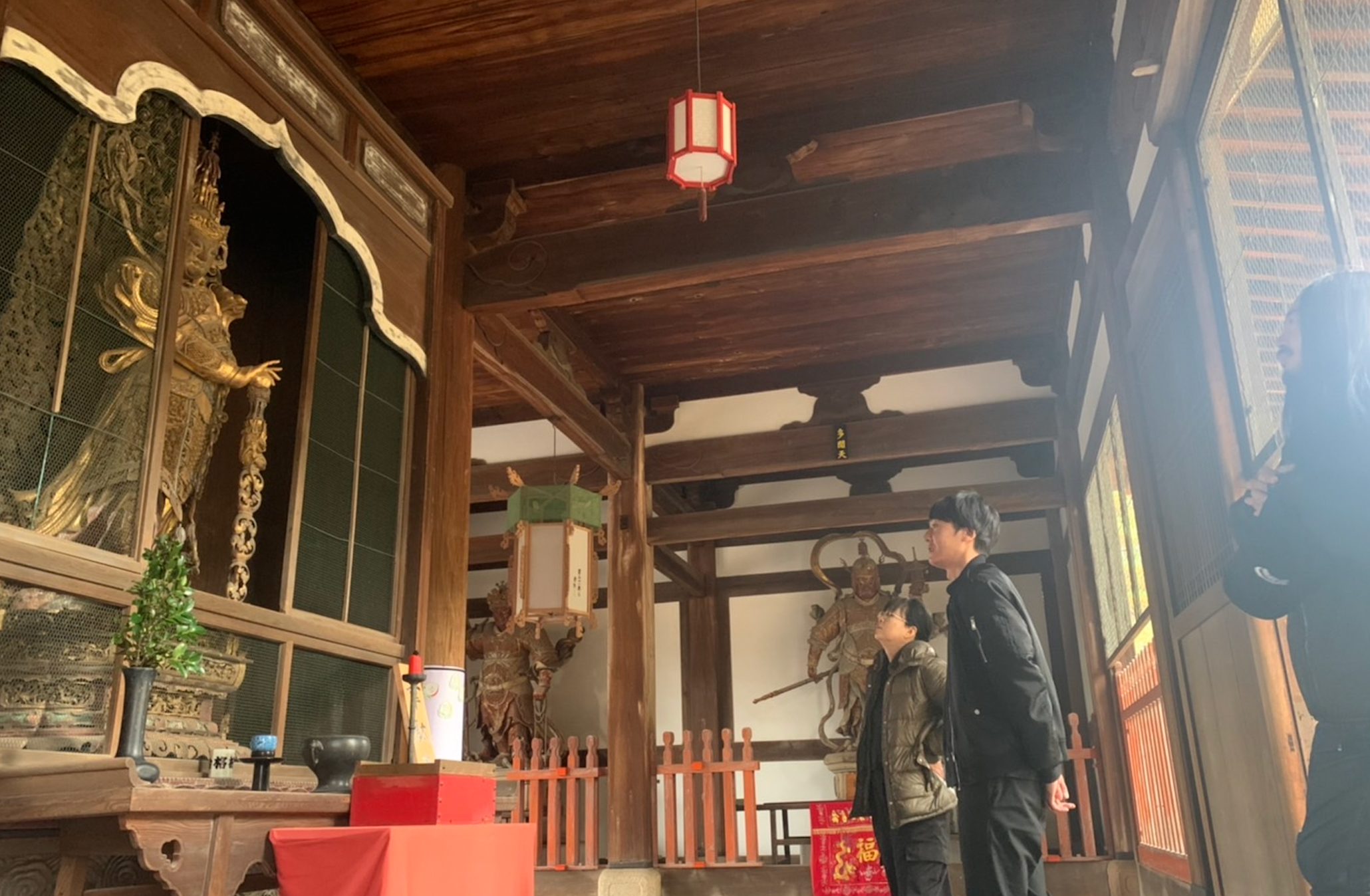 韋駄天像を鑑賞するアーティストら境内でのフィールドワーク