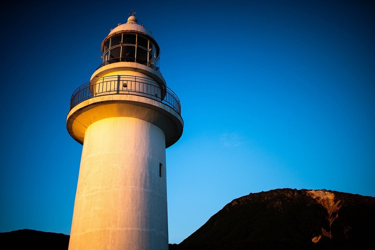 朝日をあびて輝く恵山岬灯台と、恵山