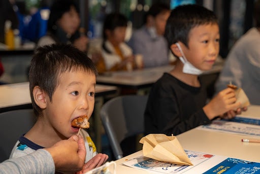 ▲函館ブリたれカツを美味しそうに試食する子どもたち