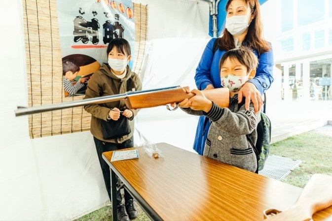 △海面に流れていたり、砂浜に落ちていたりする海ごみが的になった「射的」で遊ぶ様子