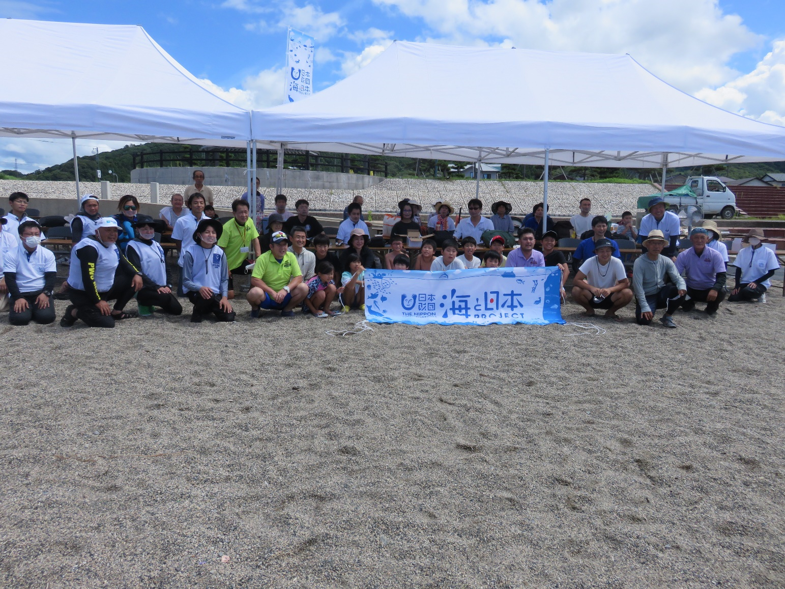 記念撮影（日差しが強いため、障がい者の方はテント内から参加）