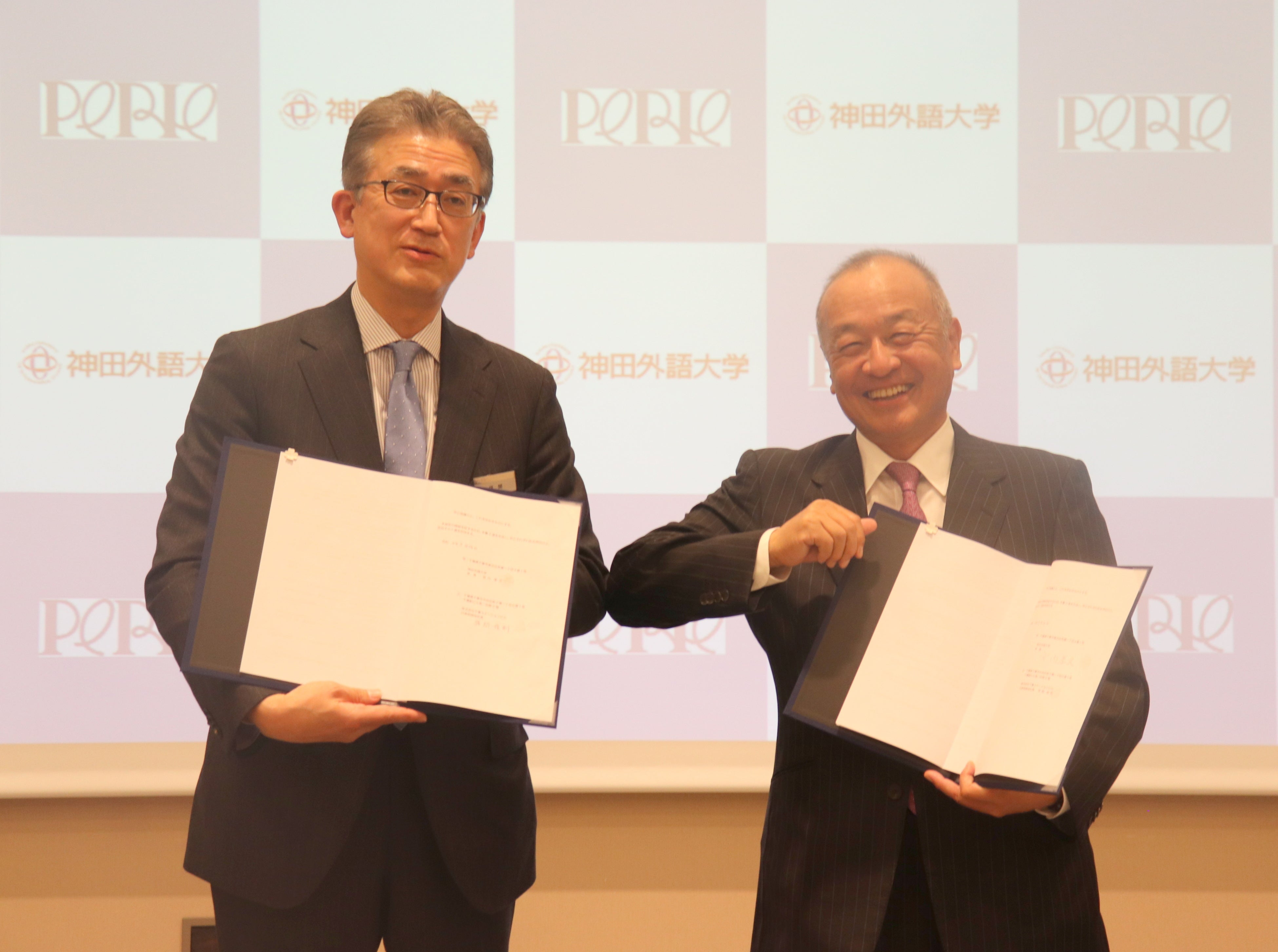 ▲記念撮影の様子(左：株式会社千葉ステーションビル 代表取締役社長 弭間俊則 氏　 右：神田外語大学 学長 宮内孝久)