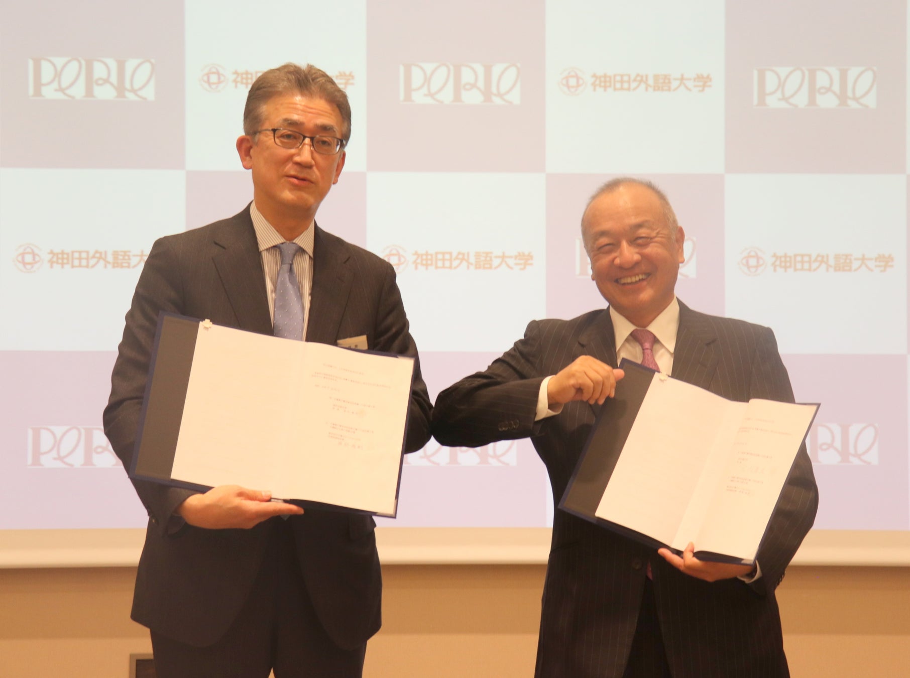 ▲記念撮影の様子(左:株式会社千葉ステーションビル 代表取締役社長 弭間俊則 氏  右:神田外語大学 学長 宮内孝久)