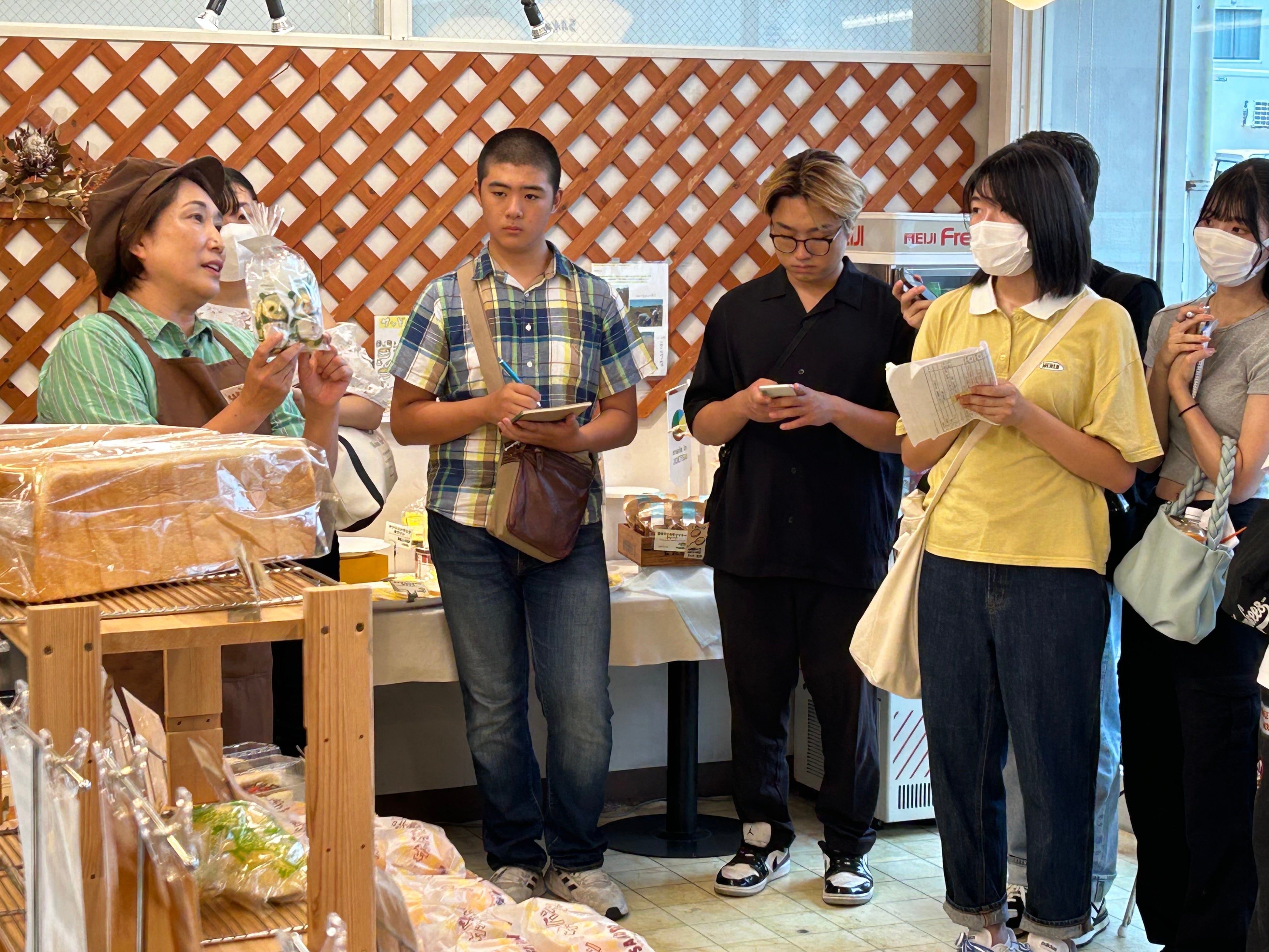 ▲現地にて生産者の話を聞く学生・生徒たち(小竹製菓)