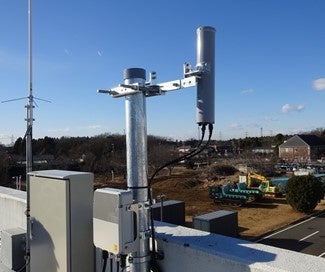 写真―１　屋外実験ヤード内へ向けられたNEC製ローカル5G基地局とアンテナ