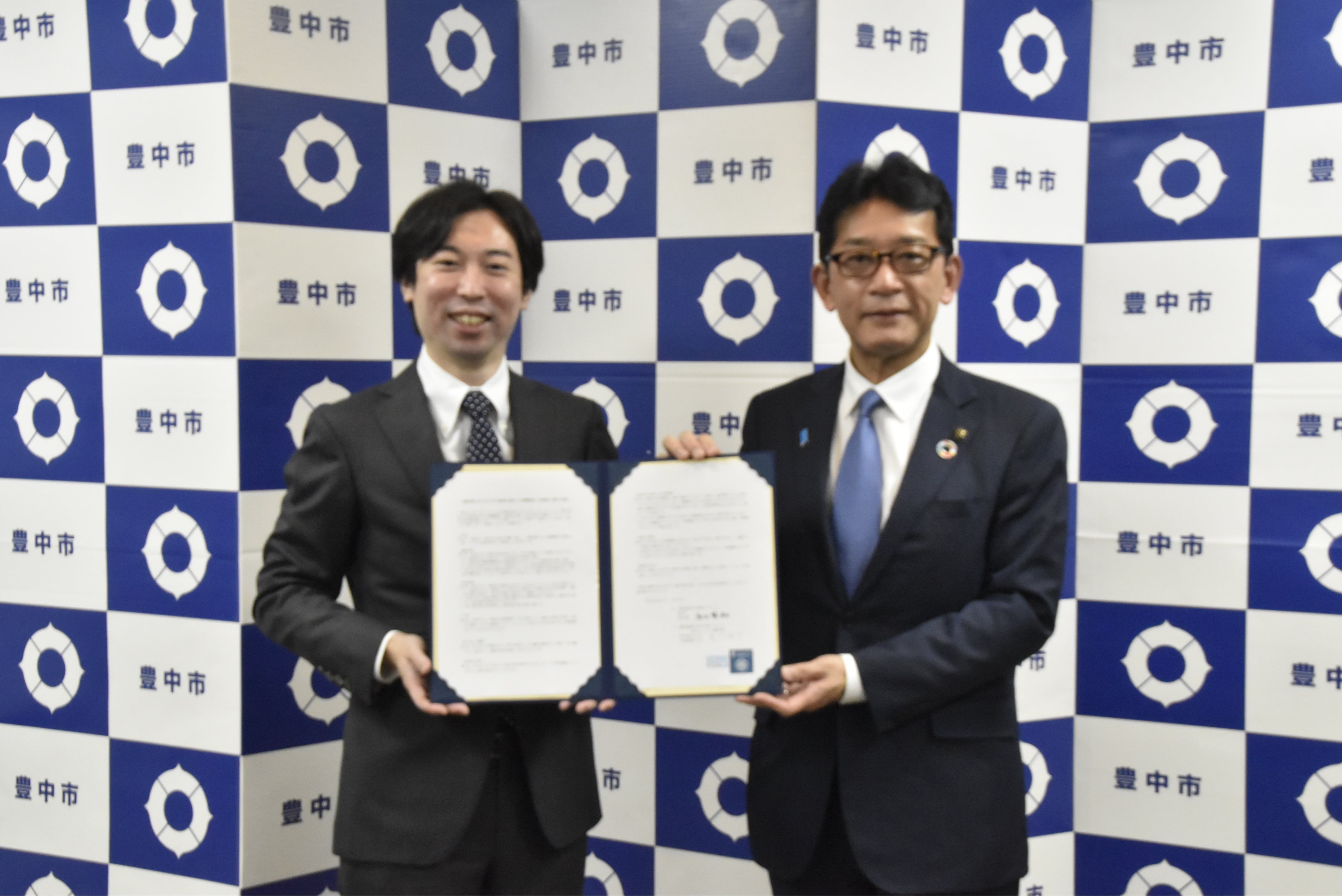 協定締結式での株式会社ウェルモ 鹿野 佑介代表取締役ＣＥＯ（左）・長内繁樹豊中市長（右）