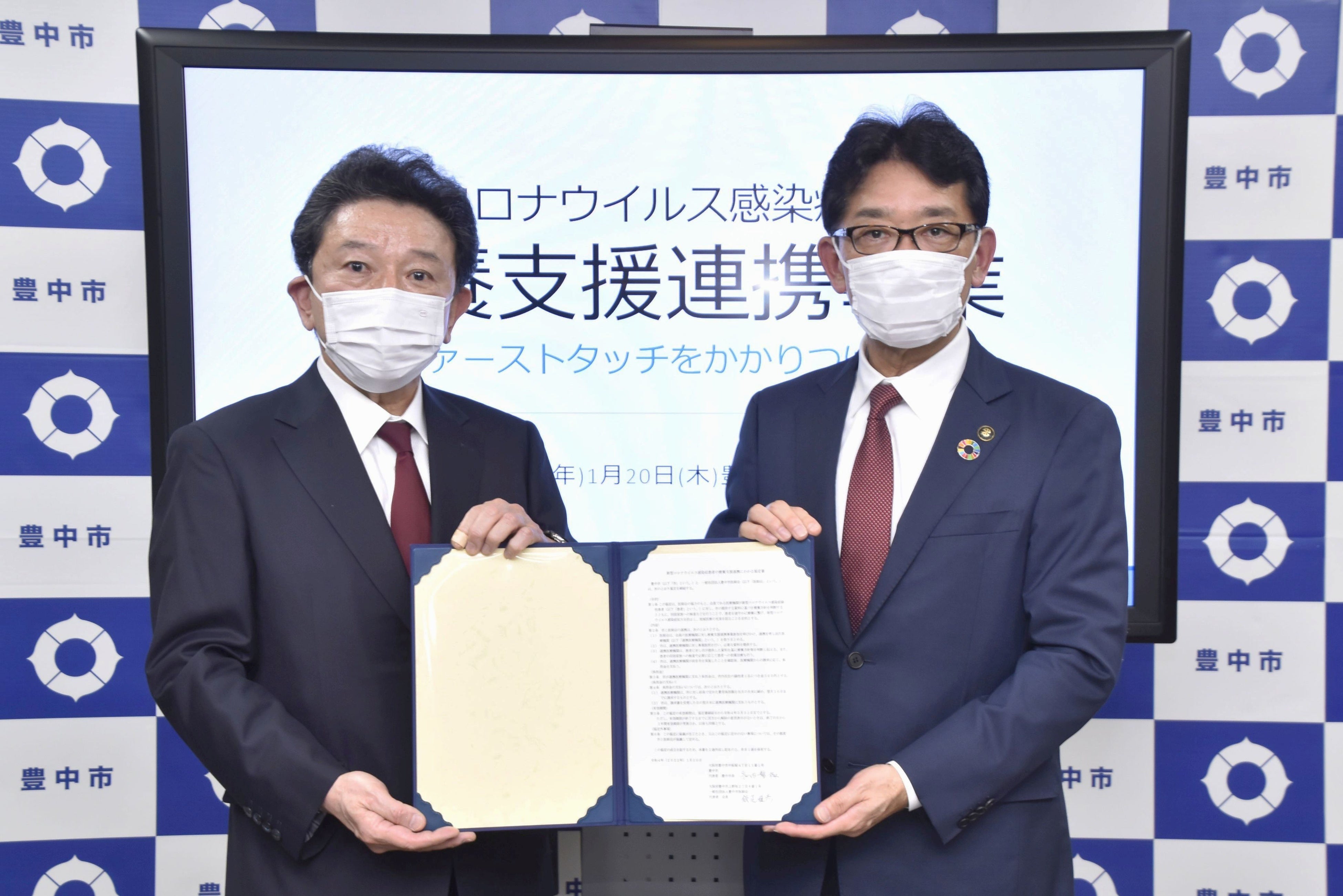 協定締結式での豊中市医師会　飯尾雅彦会長（左）・長内繁樹豊中市長（右）