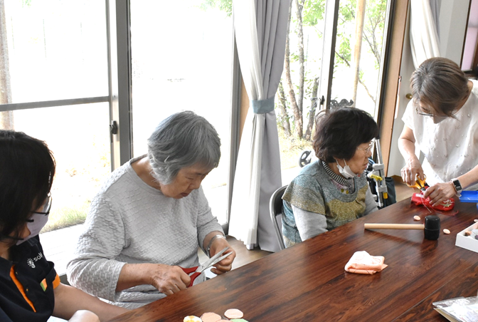 オレンジ夢リングをまとめるボタンの製作をお手伝い