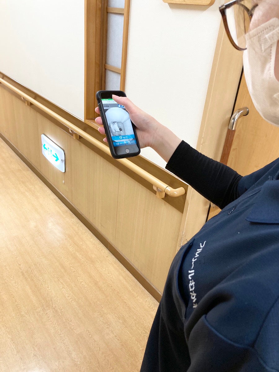 　（スマートフォンで利用者様の様子を確認している様子）