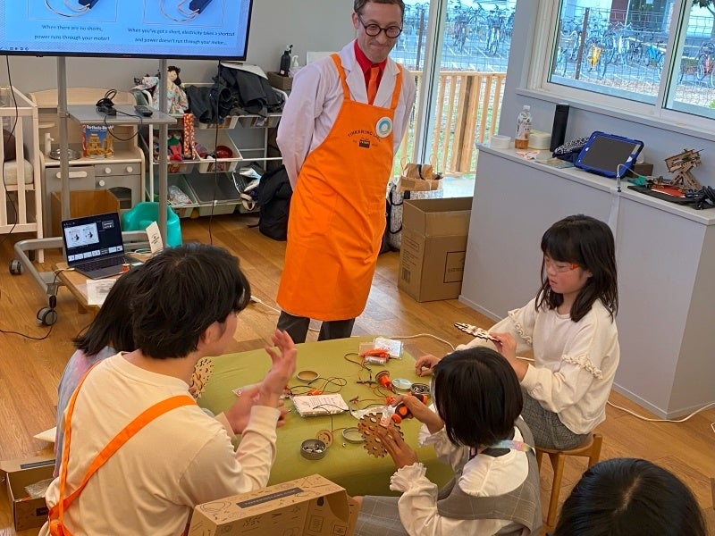 講師と話しながら部品を組み立てる子どもたち