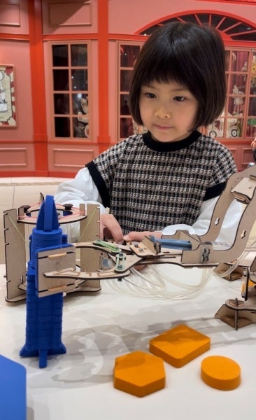 ロボットハンドでタワーを作る女の子