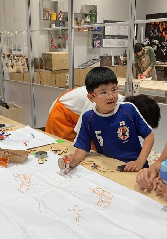 予想外のマシーンの動きに笑っている子ども