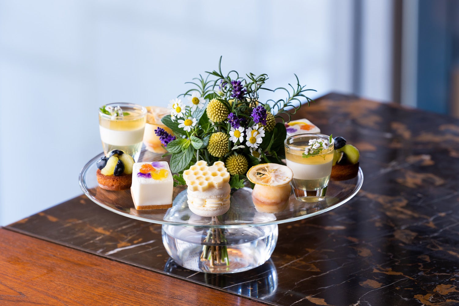 春の野原のようなお花のデコレーションをぐるりと囲む5種のスイーツ。