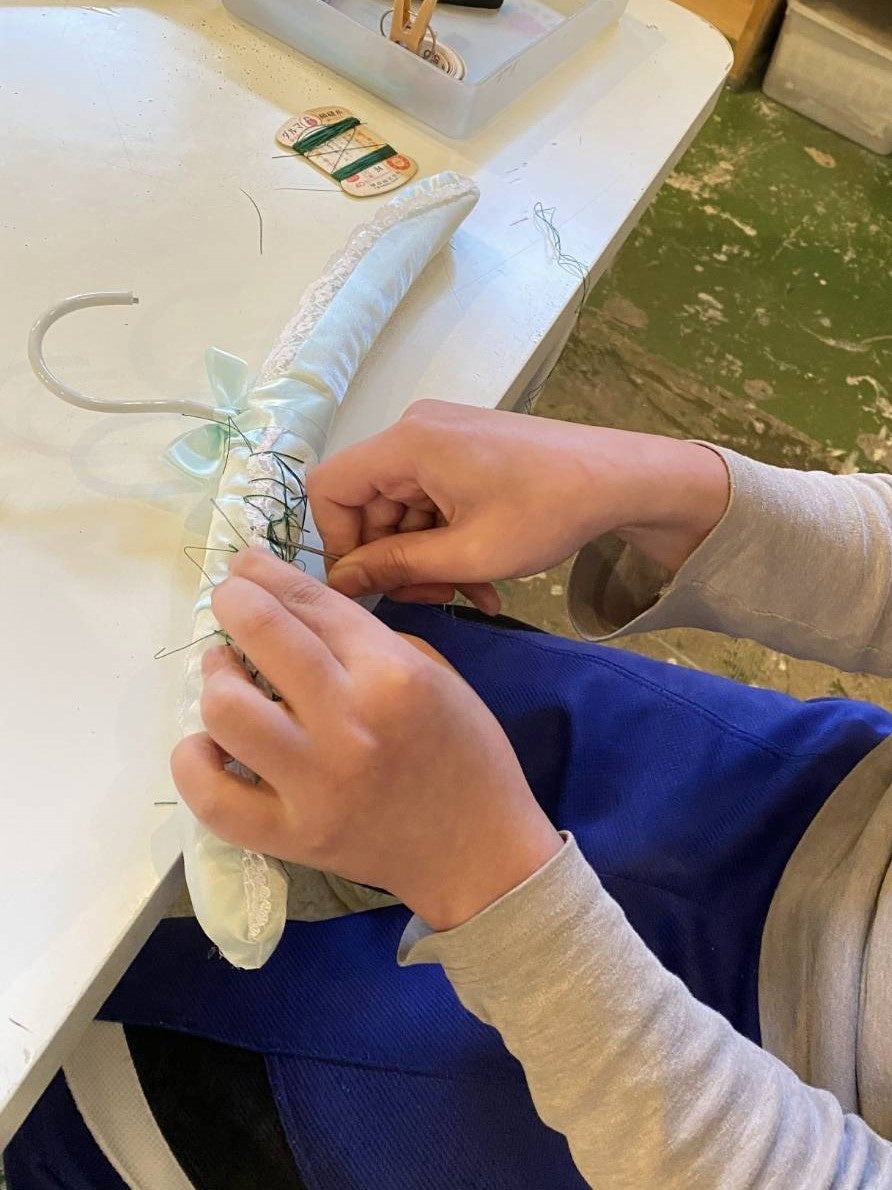 制作の様子：布ハンガーに刺繡を施す様子