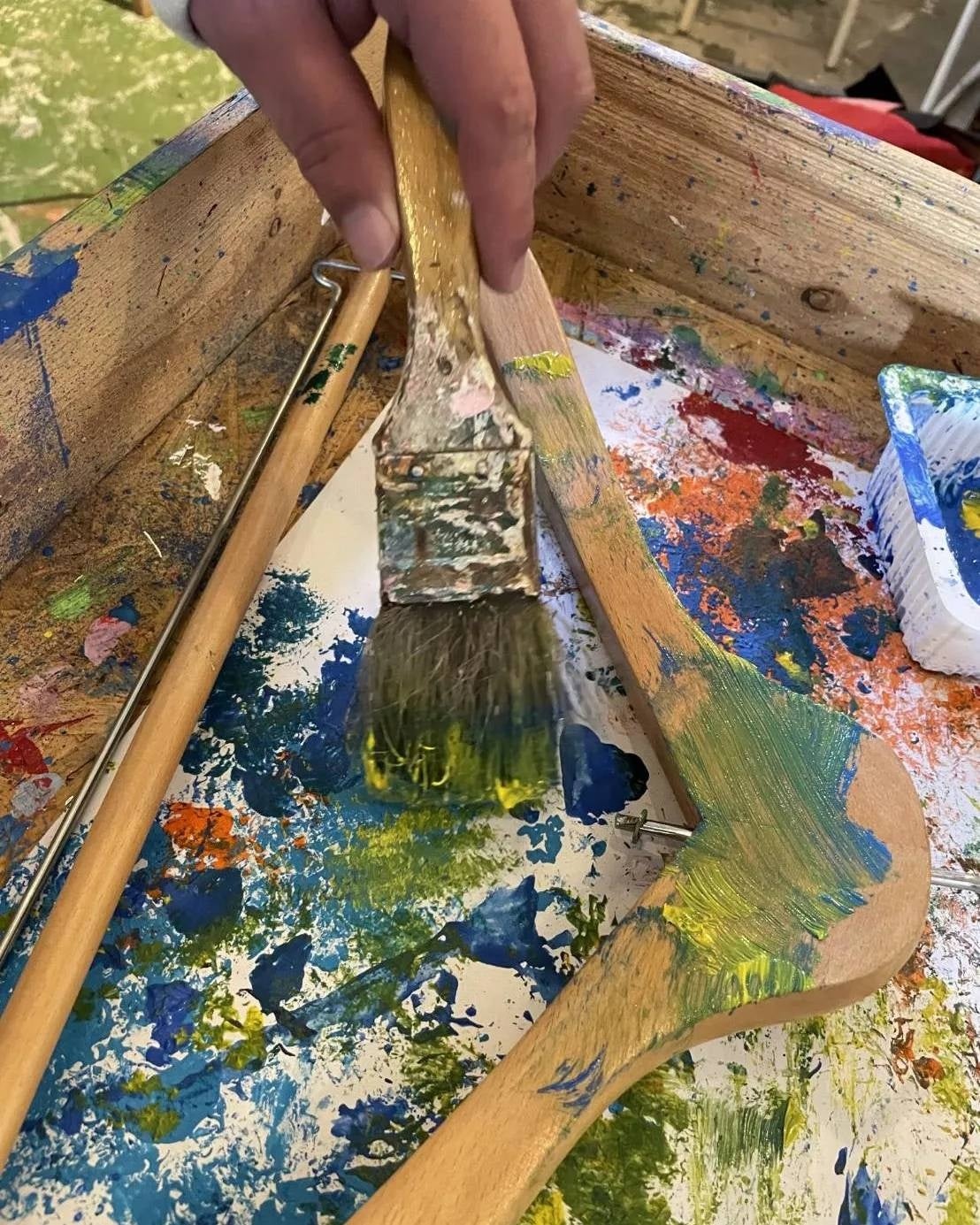 制作の様子：木製ハンガーにペイントを施す様子