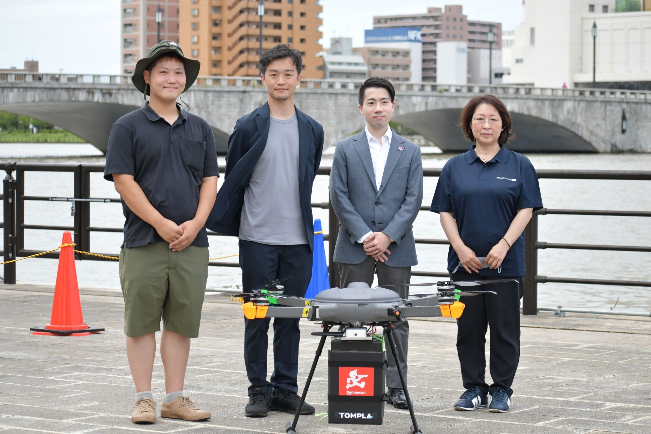 使用したドローンを前に写真向かって左より、ピーエイ ハジマリヒロバ支配人莨谷大、TOMPLA代表取締役藤本高史、出前館シェアリングデリバリー本部長執行役員森山海太、弘真物流代表取締役社長 大関真子