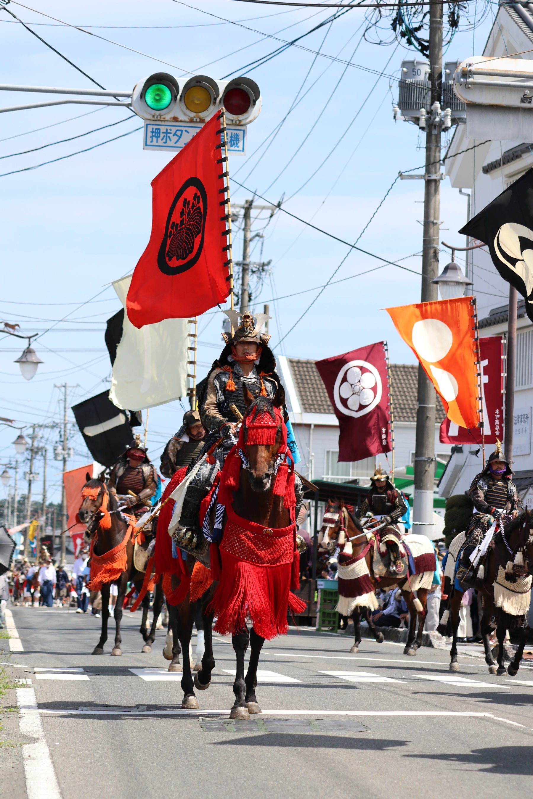 先祖伝来の旗を背に進む