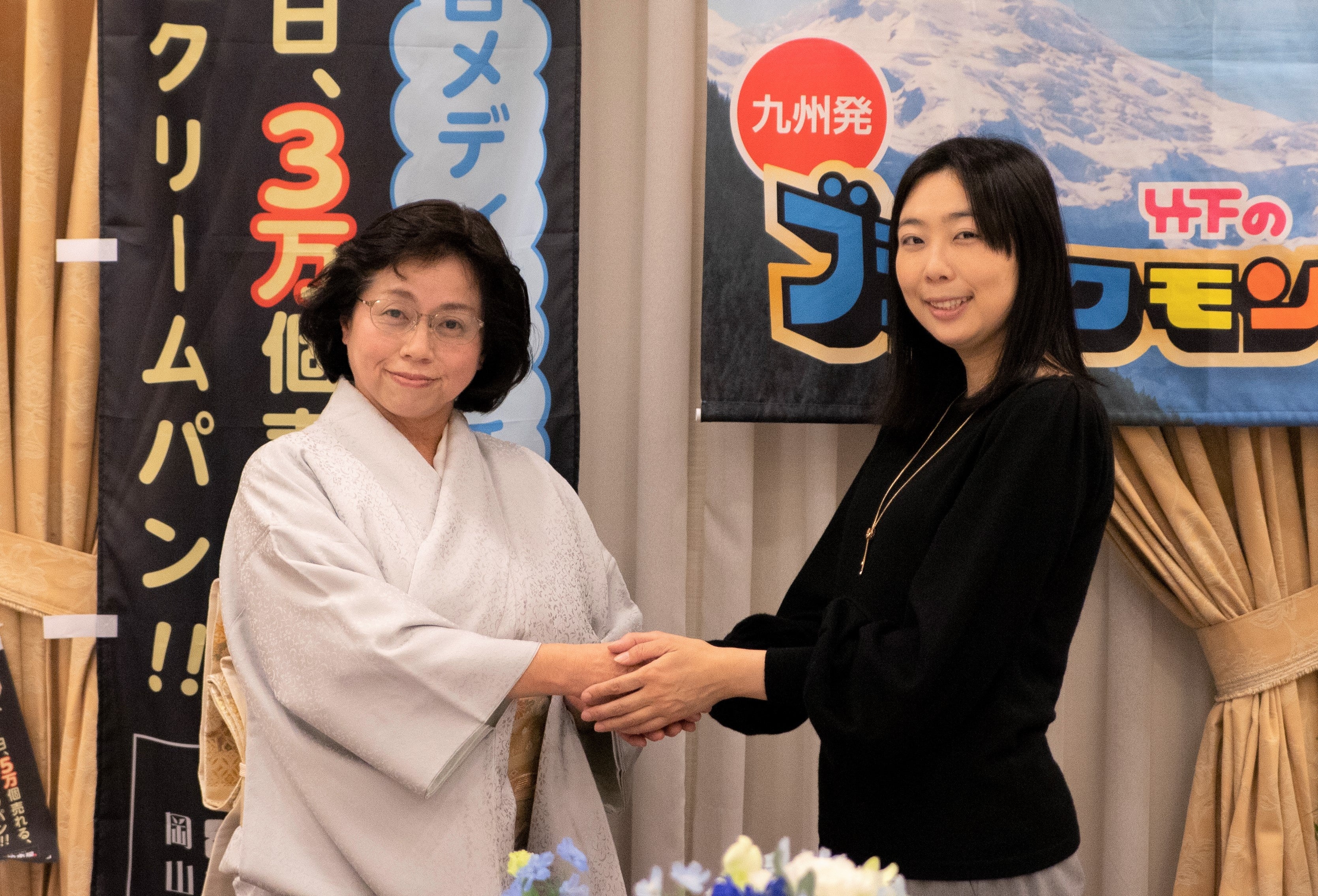 2022年1月5日に岡山市のホテルで行われた成約式。固い握手を交わす清水敬子前社長（左）と竹下真由社長（右）