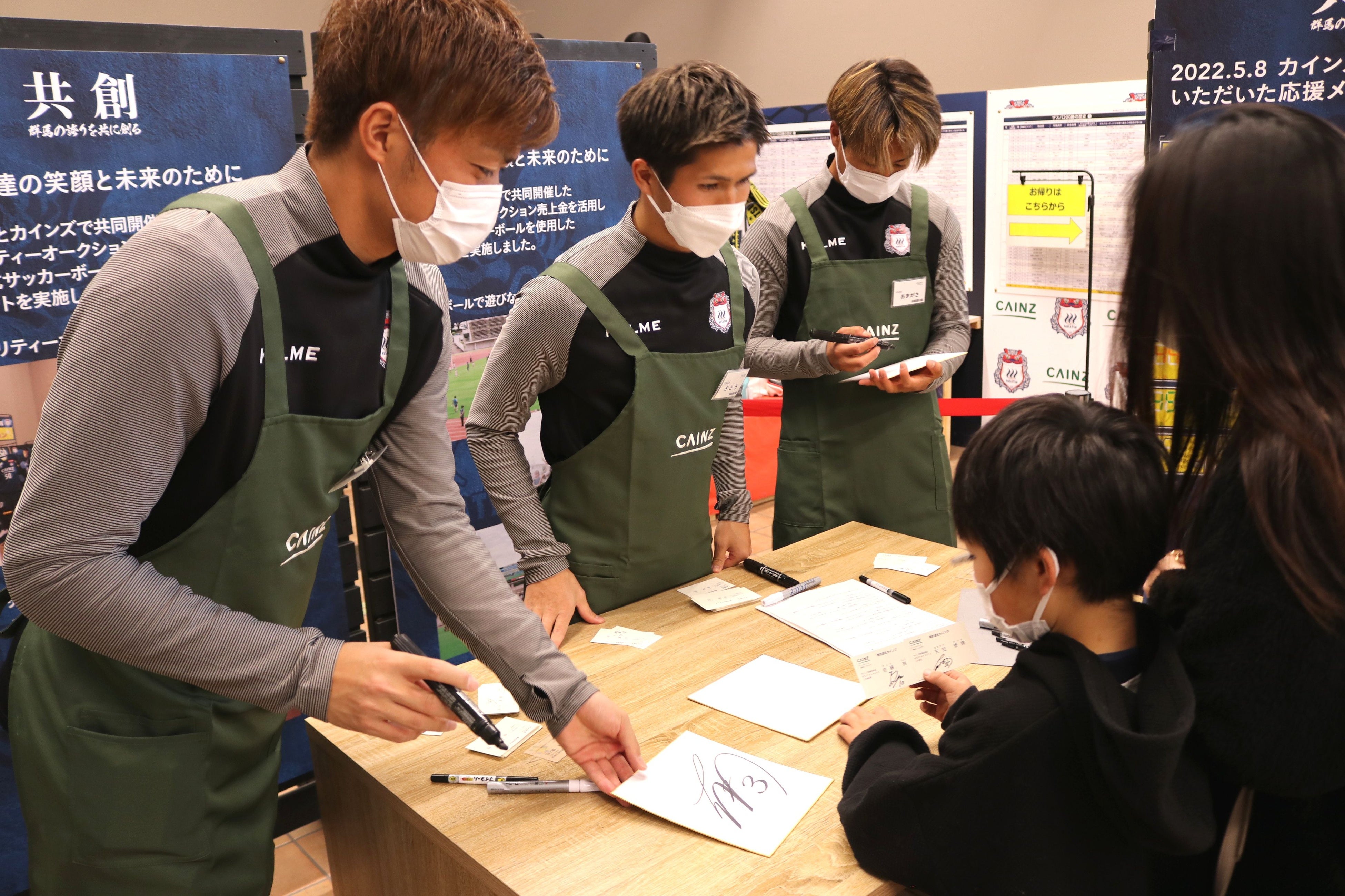 サイン色紙や名刺を手渡す3選手