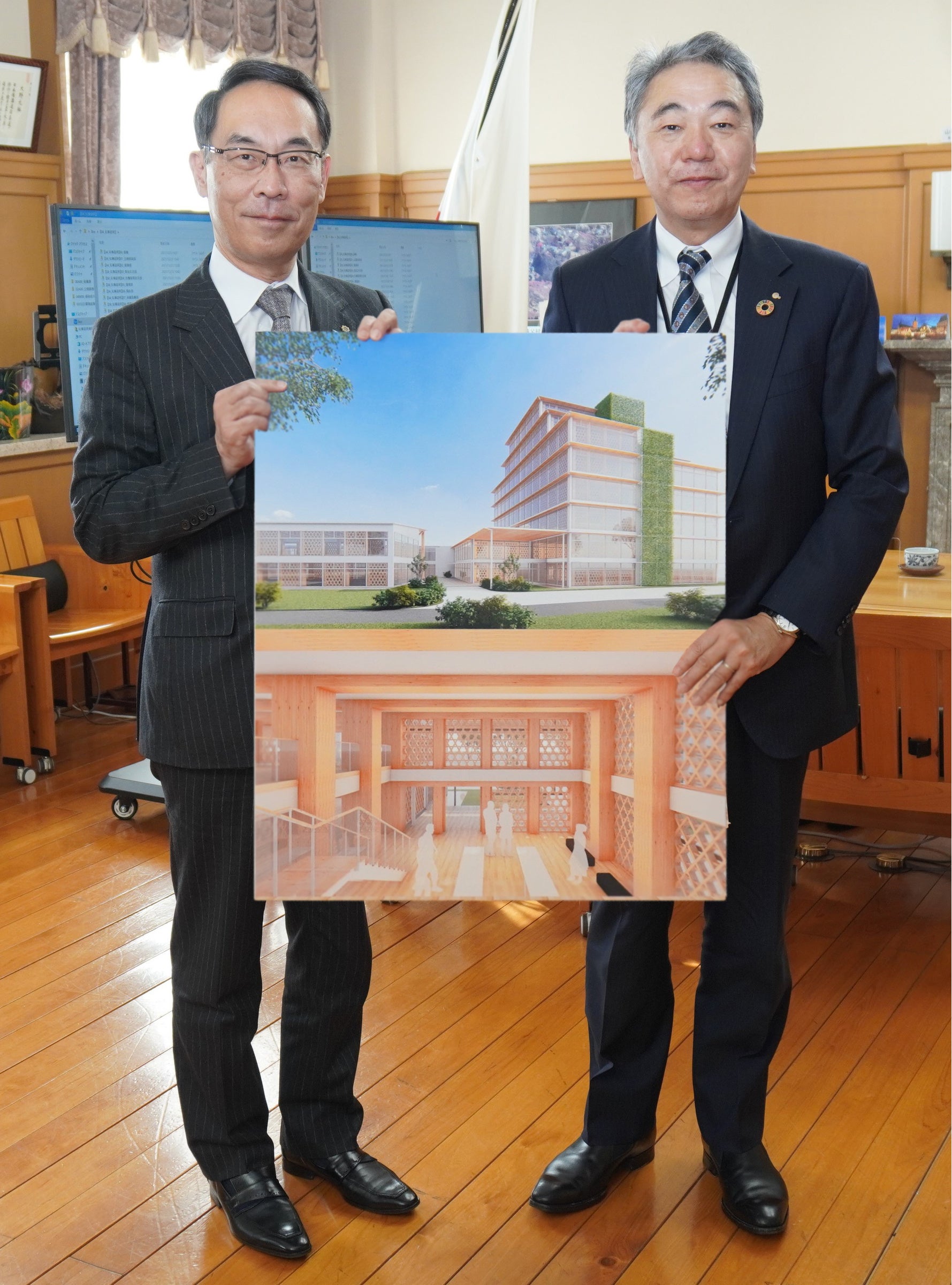 大野知事（左）、社長宮沢（右） パネルは「木造建築プロトタイプとなる新社屋完成図