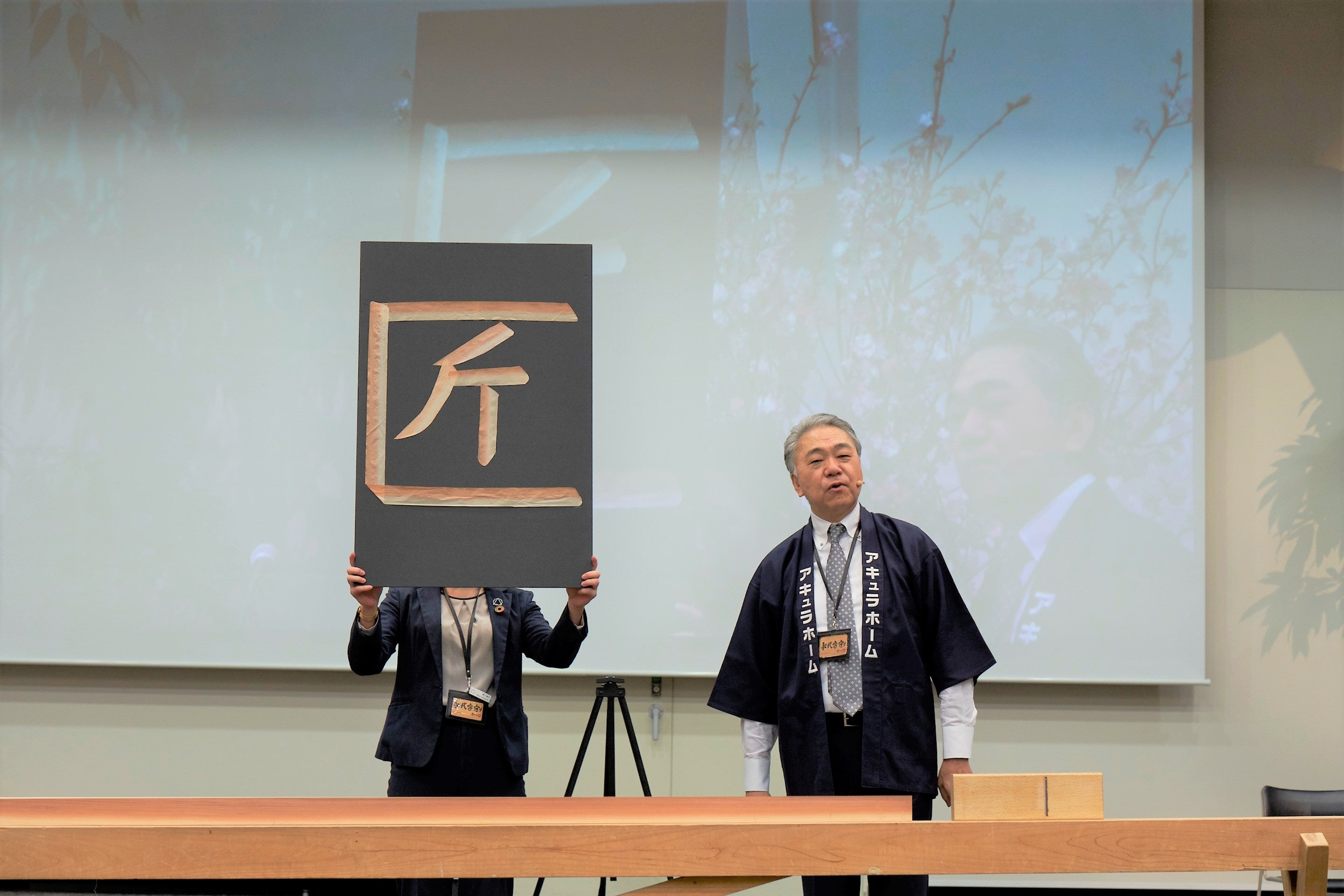 社長と新入社員、大工で作る「匠」文字