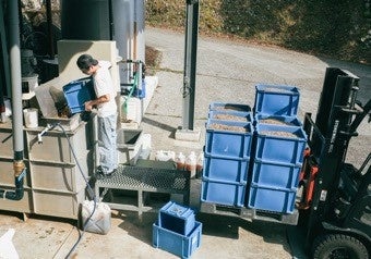 reRise液肥生成装置にモルトかすを投入するスタッフ（RISE&WIN工場内）