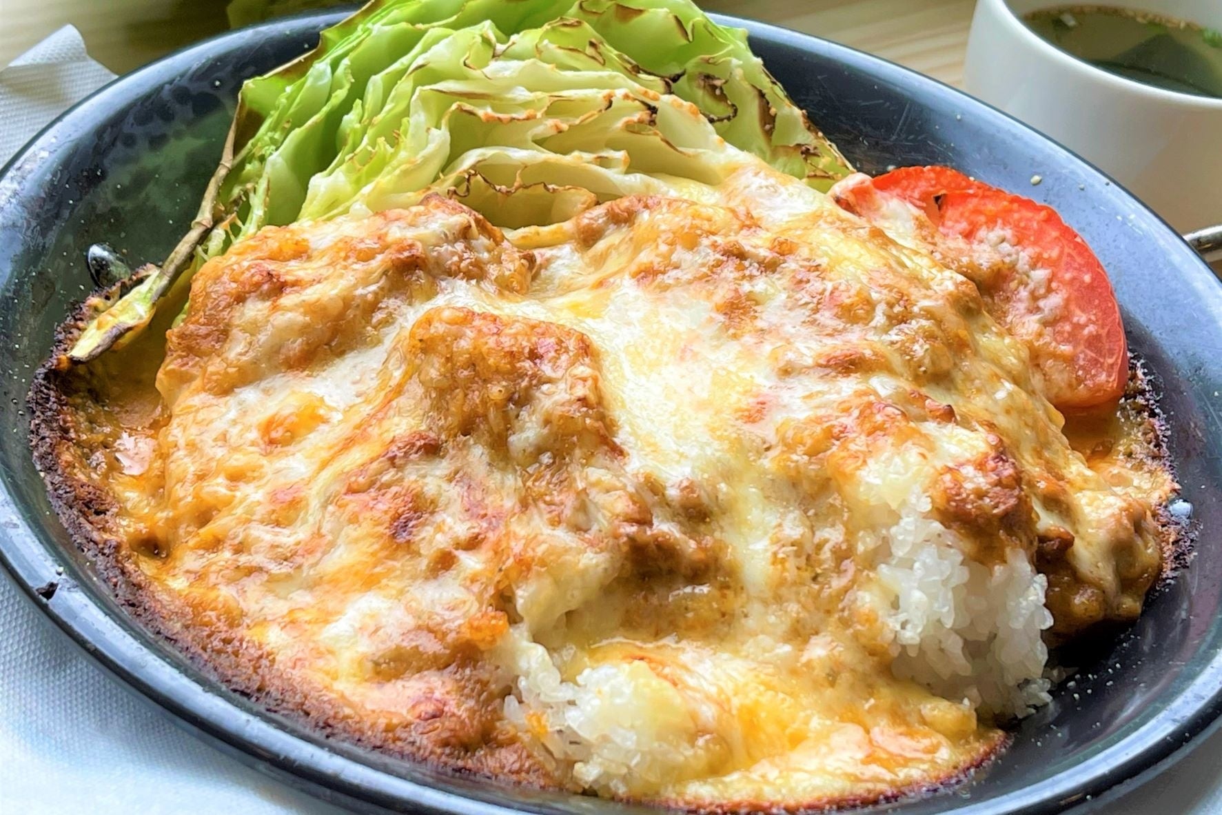 ペースト状のキャベツとカレーを合わせ、オリジナルチーズと一緒に焼いた絶品の「焼きチーズグリーンカレー」