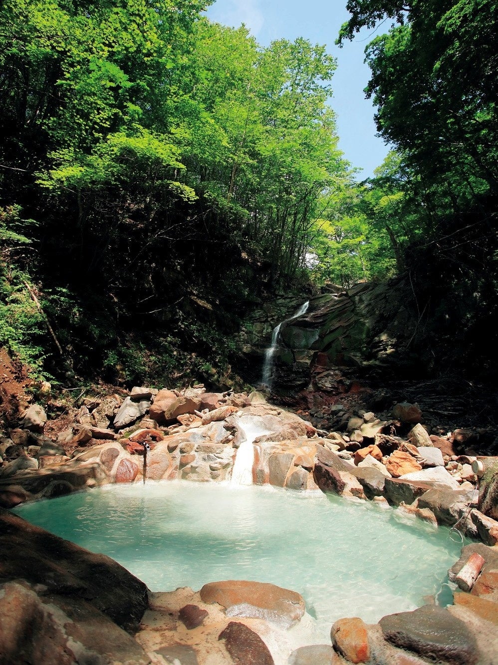 滝の流れ落ちる沢沿いにある野趣あふれる野天風呂です