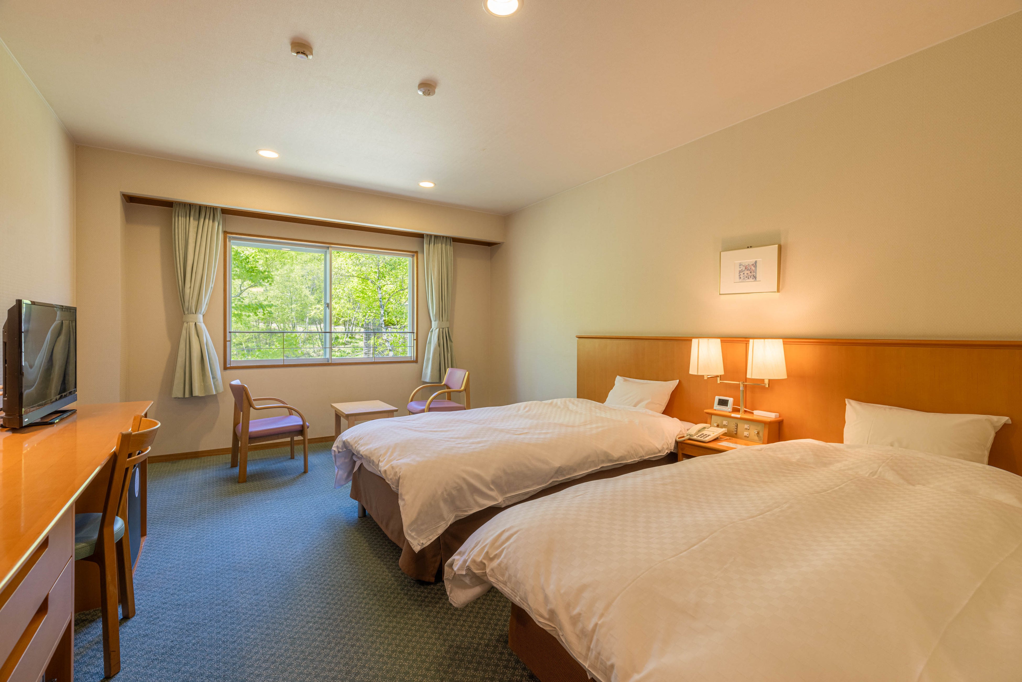 周囲を木立に囲まれた自然を望む落ち着いた洋室