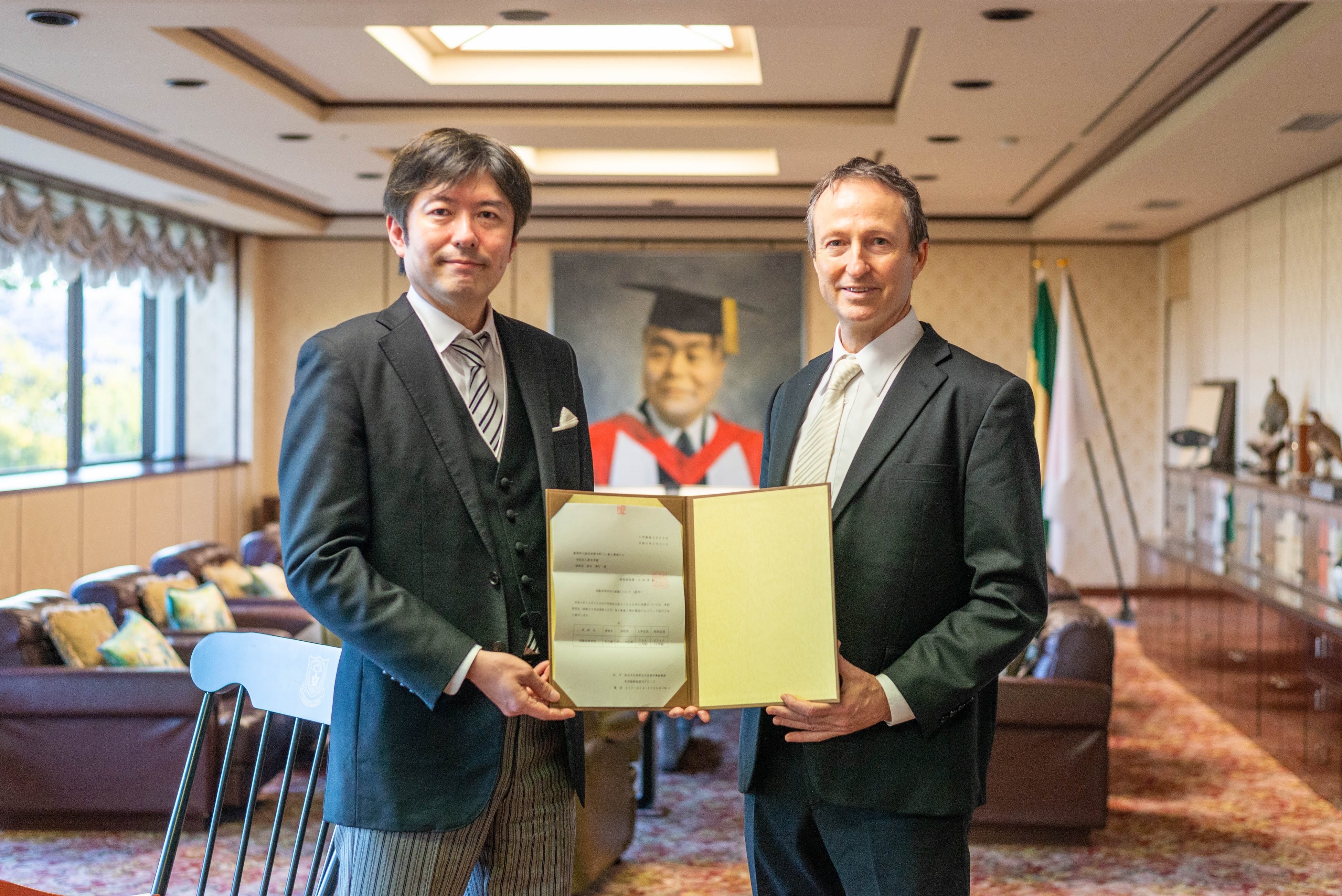 愛知県知事発行の認可書を手にする学園理事長（左）と学校長（右）