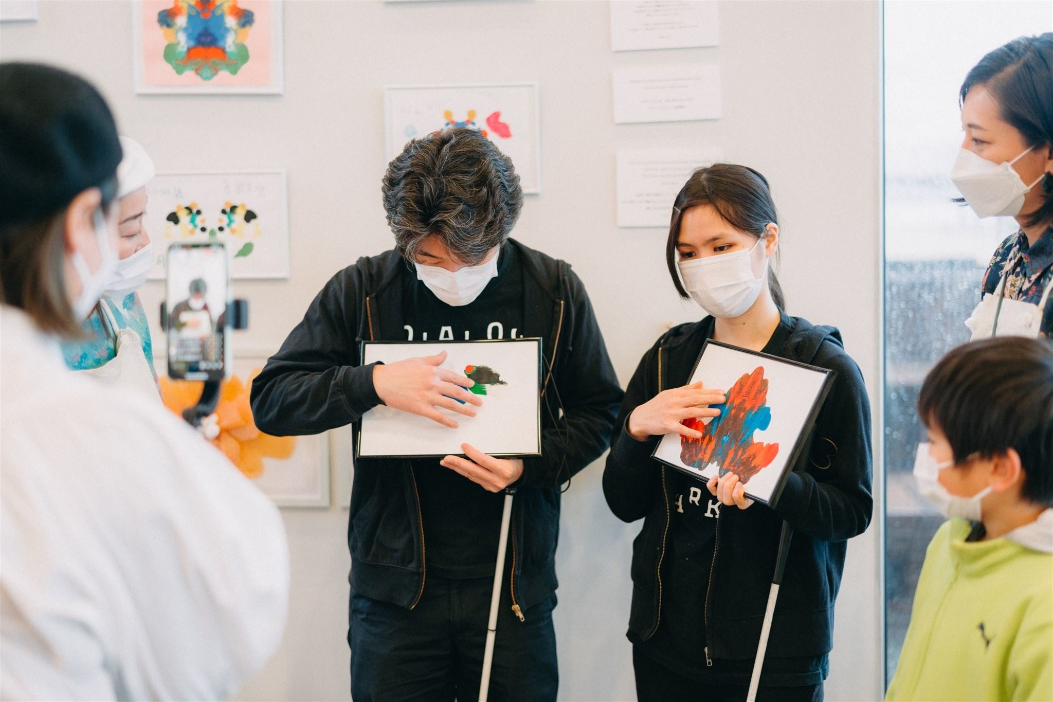 （ダイアログ・イン・ザ・ダークのアテンドのお二人（視覚障害者）とアート鑑賞をしている様子）