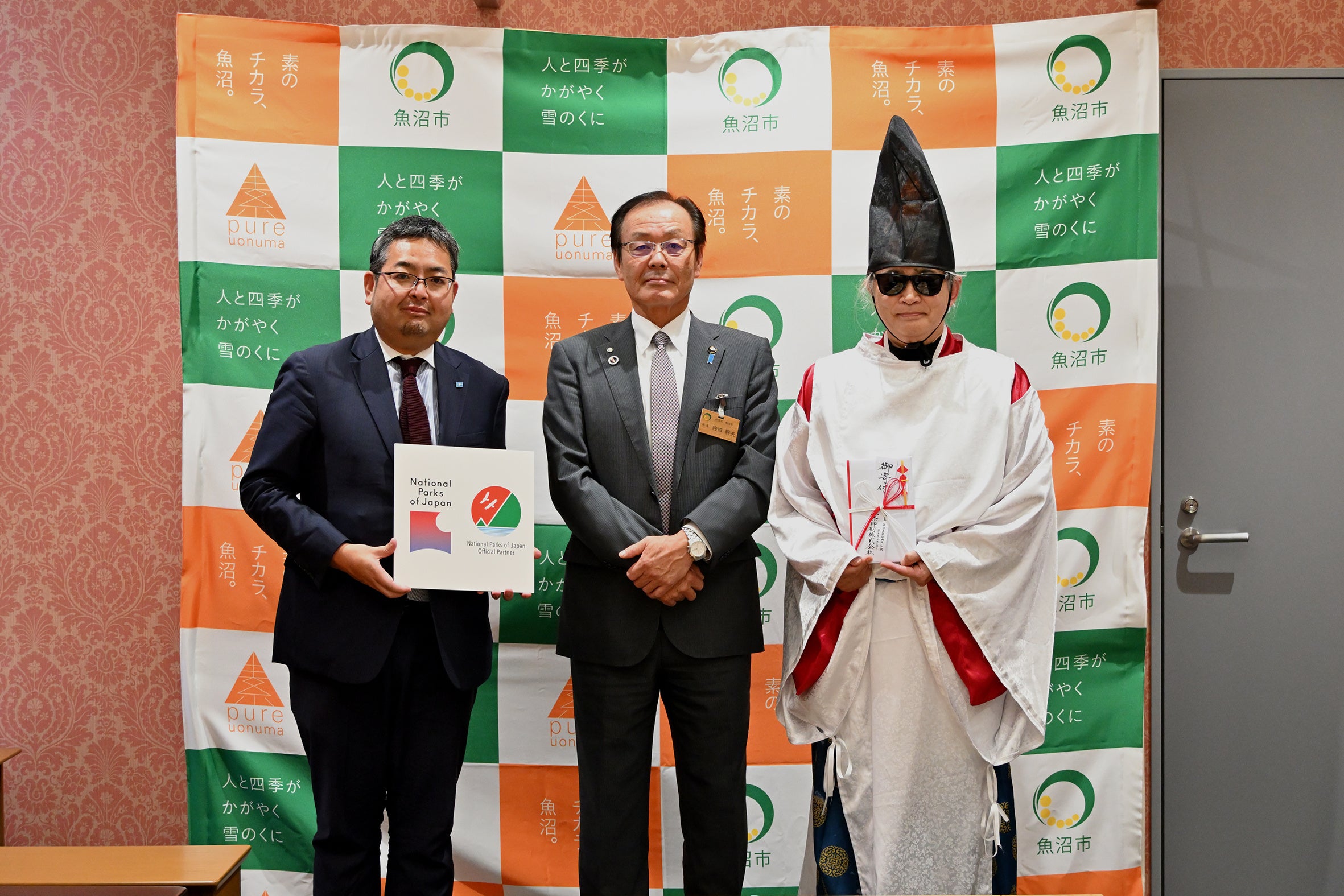 三条印刷㈱代表取締役：渋谷政道（左）と魚沼市長：内田幹男氏（中）、 魚沼に伝わる「尾瀬三郎伝説」にならった公家装束で贈呈式に出席した尾瀬ルート活性化委員会会長：星 雅彦氏（右）