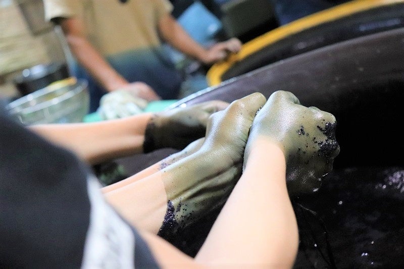 本藍染の染料で藍色に染まる子どもたちの手