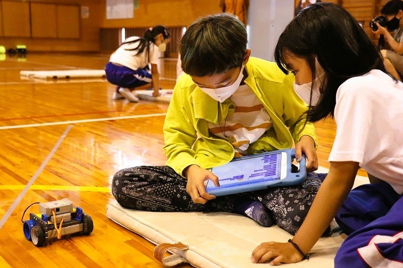 2校の児童が協力してロボットを動かす