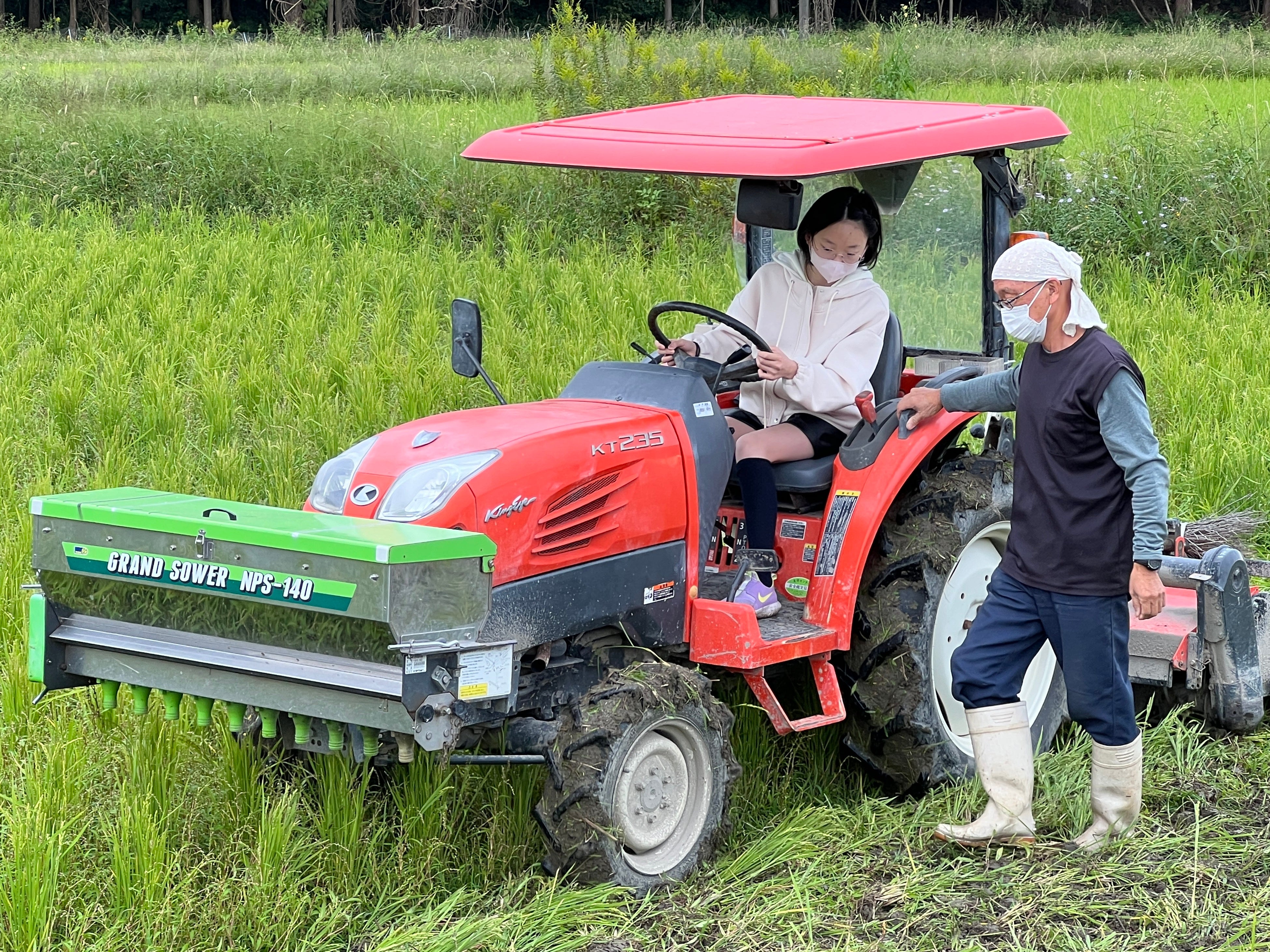 田んぼでトラクターの操縦をする子どもたち