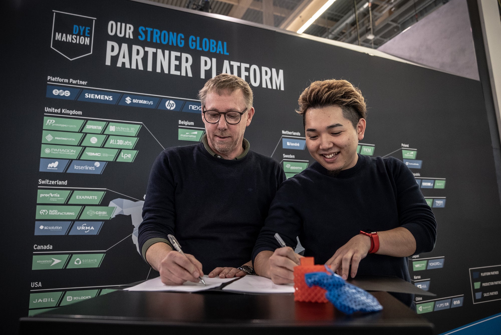 DyeMansion社 Chief Customer Officer、Kai Witter氏とYOKOITO 代表取締役CEO 中島佑太郎氏によるサイニングセレモニー（Formnext 2022にて）