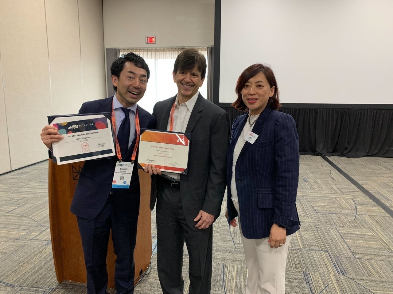 ＜左から、2つの賞状をもつユームテクノロジージャパン株式会社　代表取締役　松田しゅう平、ATD CEO Tony Bingham氏、ATDグローバルシニアディレクターWei Wang氏＞