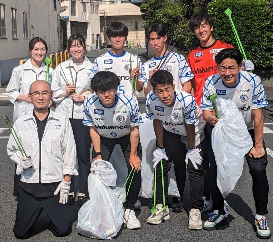 南葛SC選手とミヨシ油脂社員、宮原輝選手(上段左から３番目)、神田洸樹選手(上段左から４番目)、飯吉将通選手(上段左から５番目)、大郷海夢選手(下段左から２番目)、新井博人選手(下段左から３番目)、梶塚大哉選手(下段左から４番目)