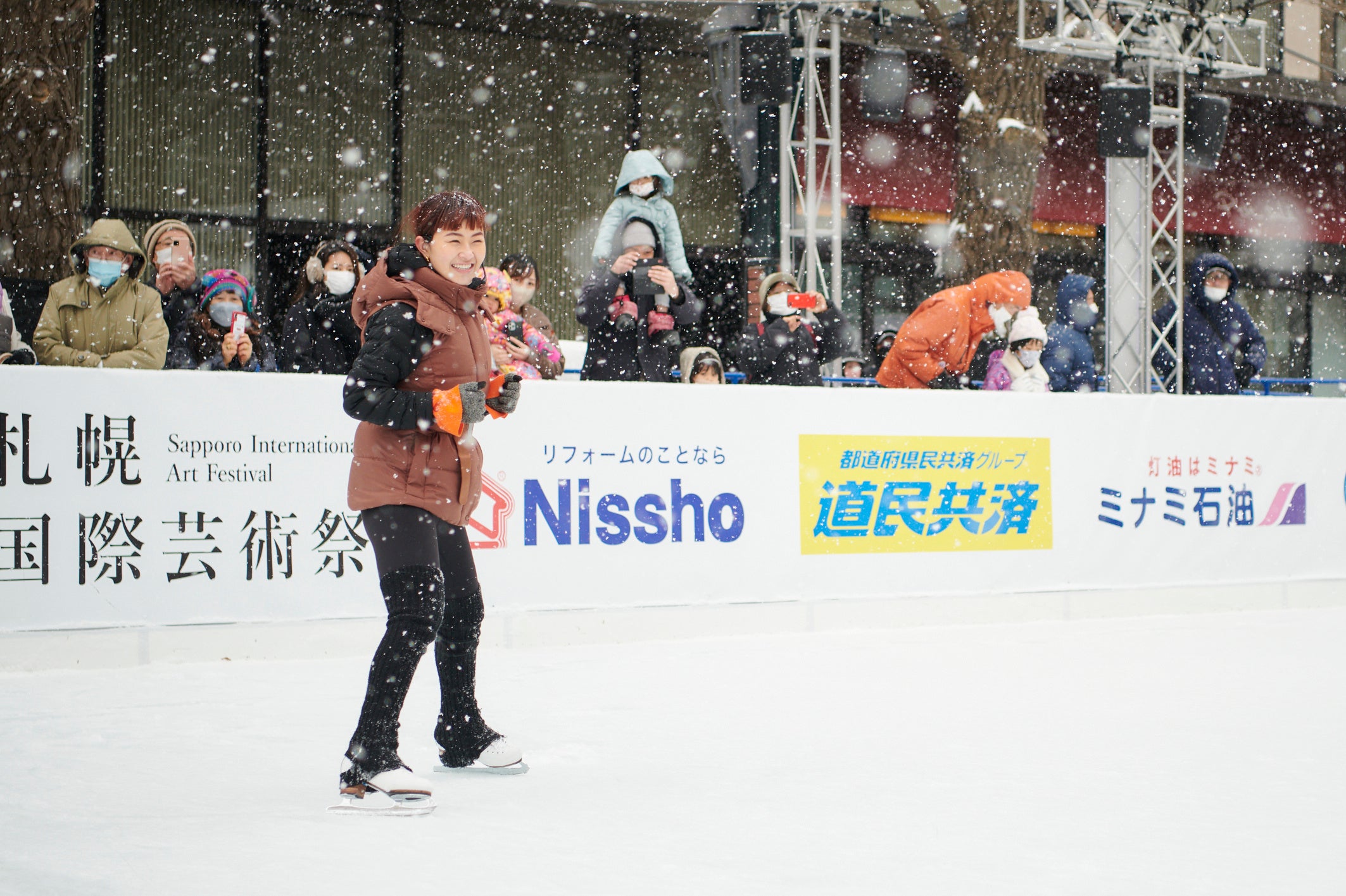 雪が舞い降りる中、スケート教室の講師を務める村上佳菜子さん。　©UHB