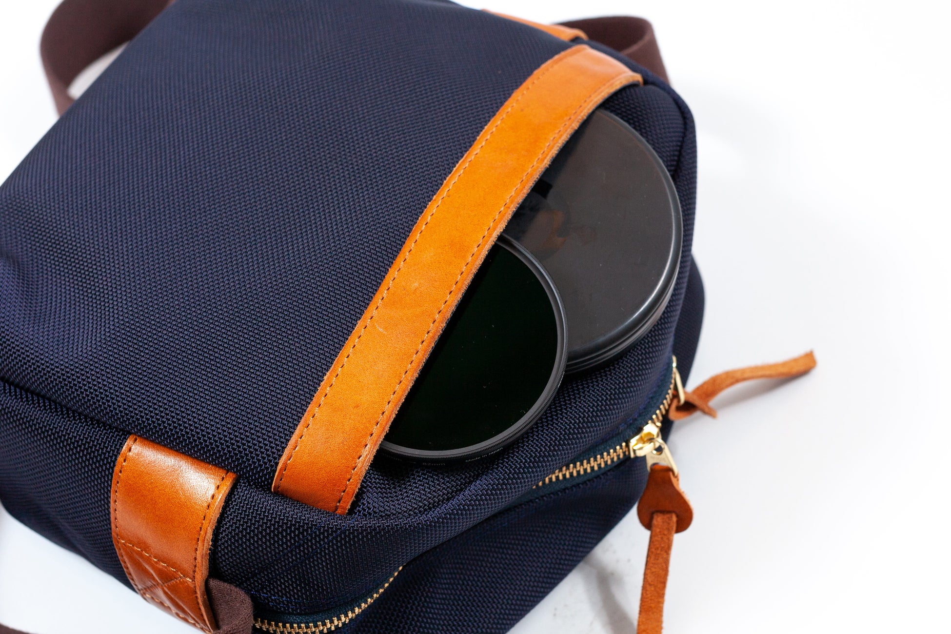 マチ付きの背面には嵩張るフィルターやレンズキャップを収納可能。