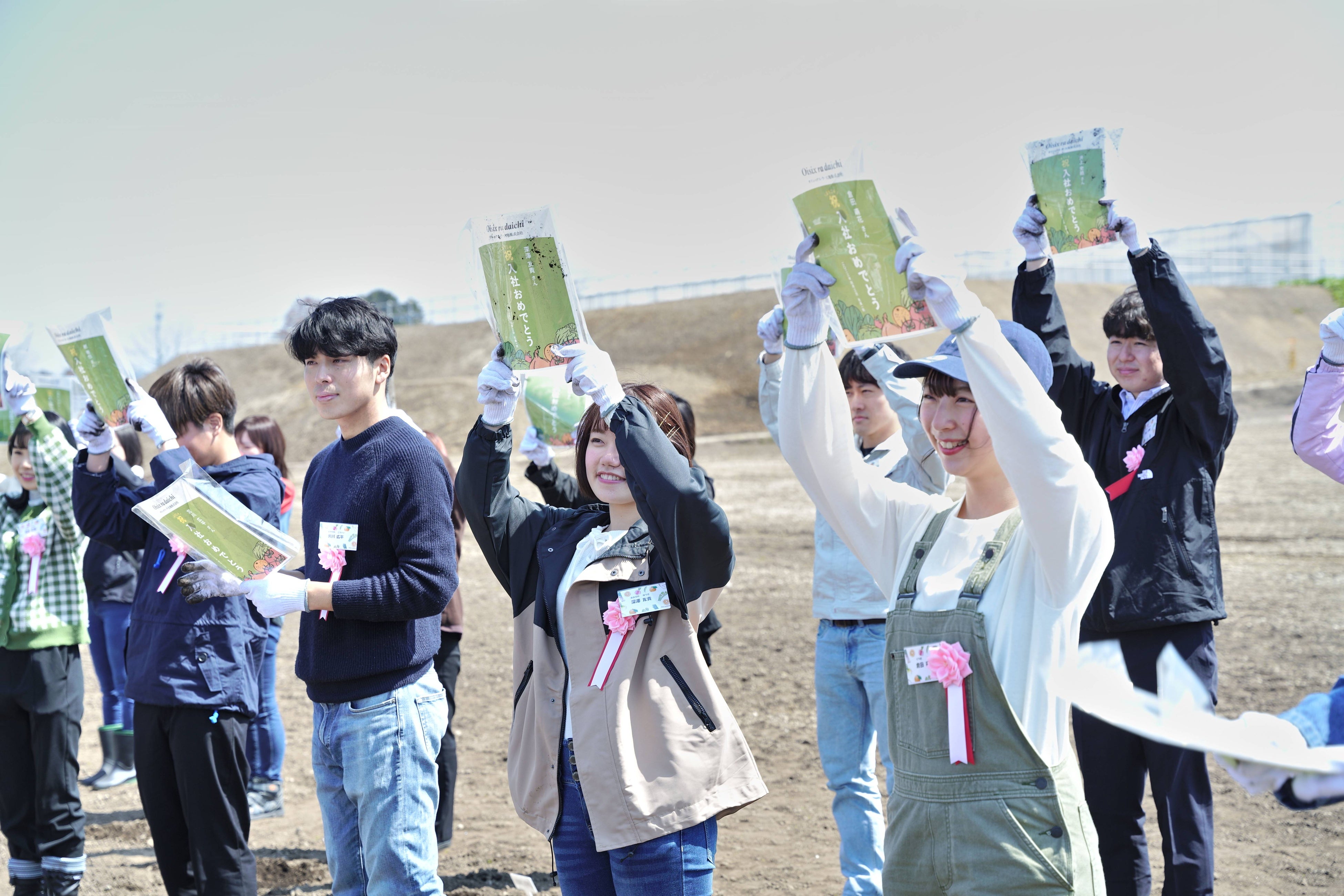 ▲収穫した入社証書を掲げる新入社員のみなさん