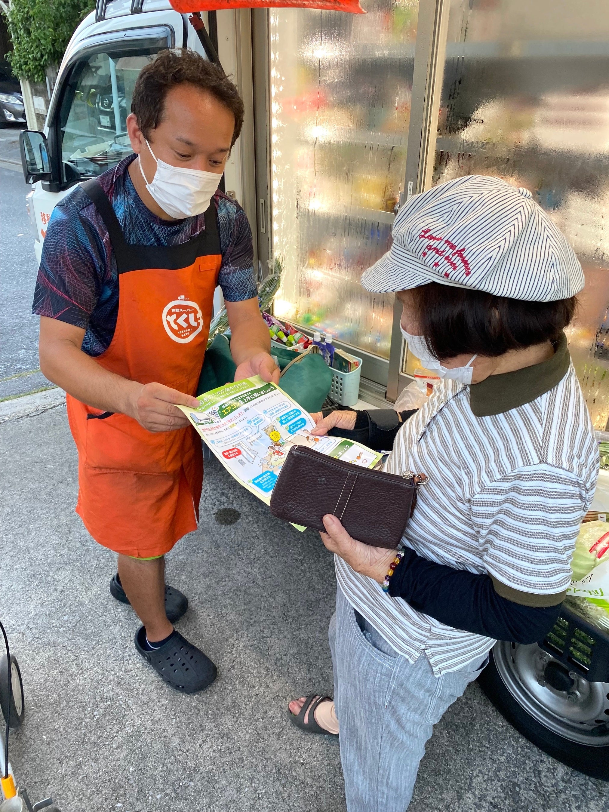 △移動スーパーとくし丸で熱中症注意喚起のリーフレットを配布している様子