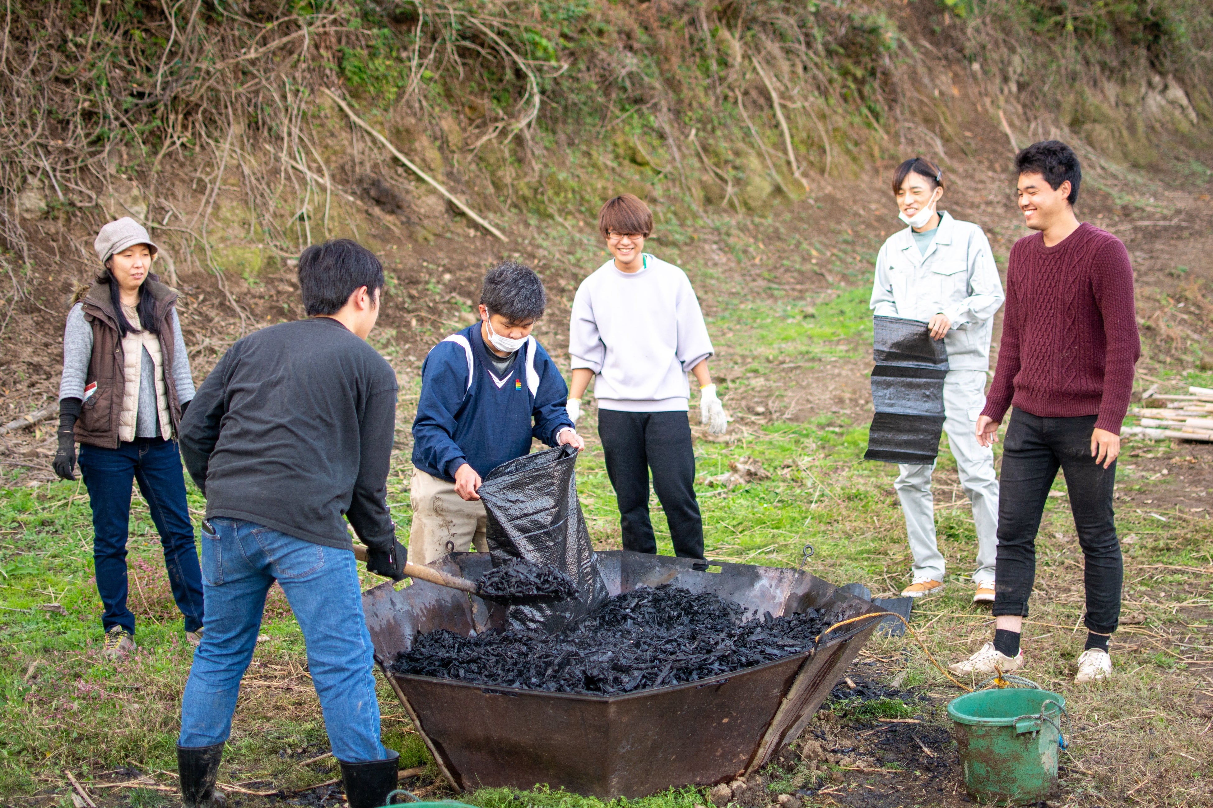 島留学生やグローカルプログラム参加者と作ったバイオ炭を回収している様子