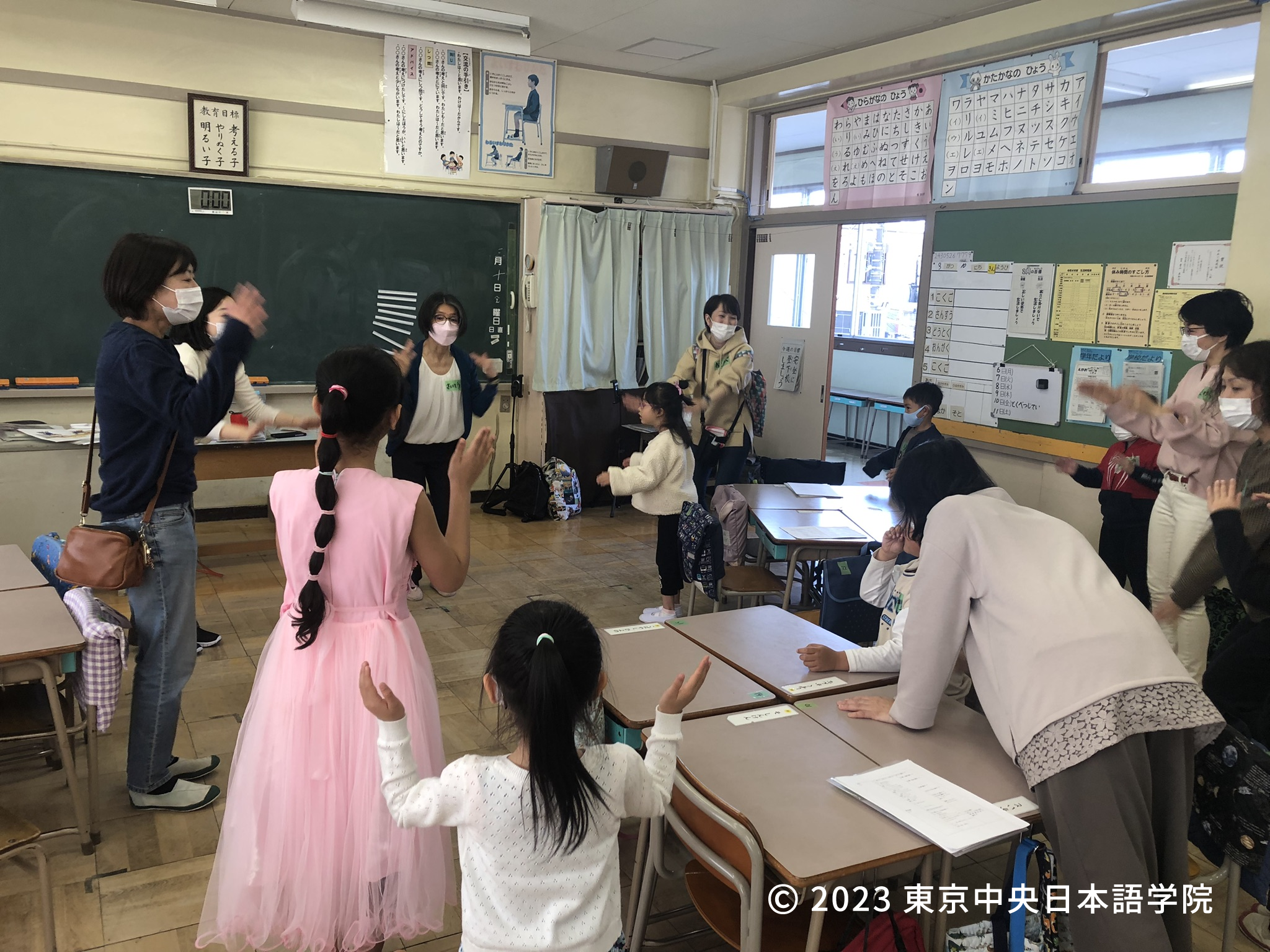 「あたま・かた・ひざ・ぽん」で体の部位を学ぶ子どもたち。