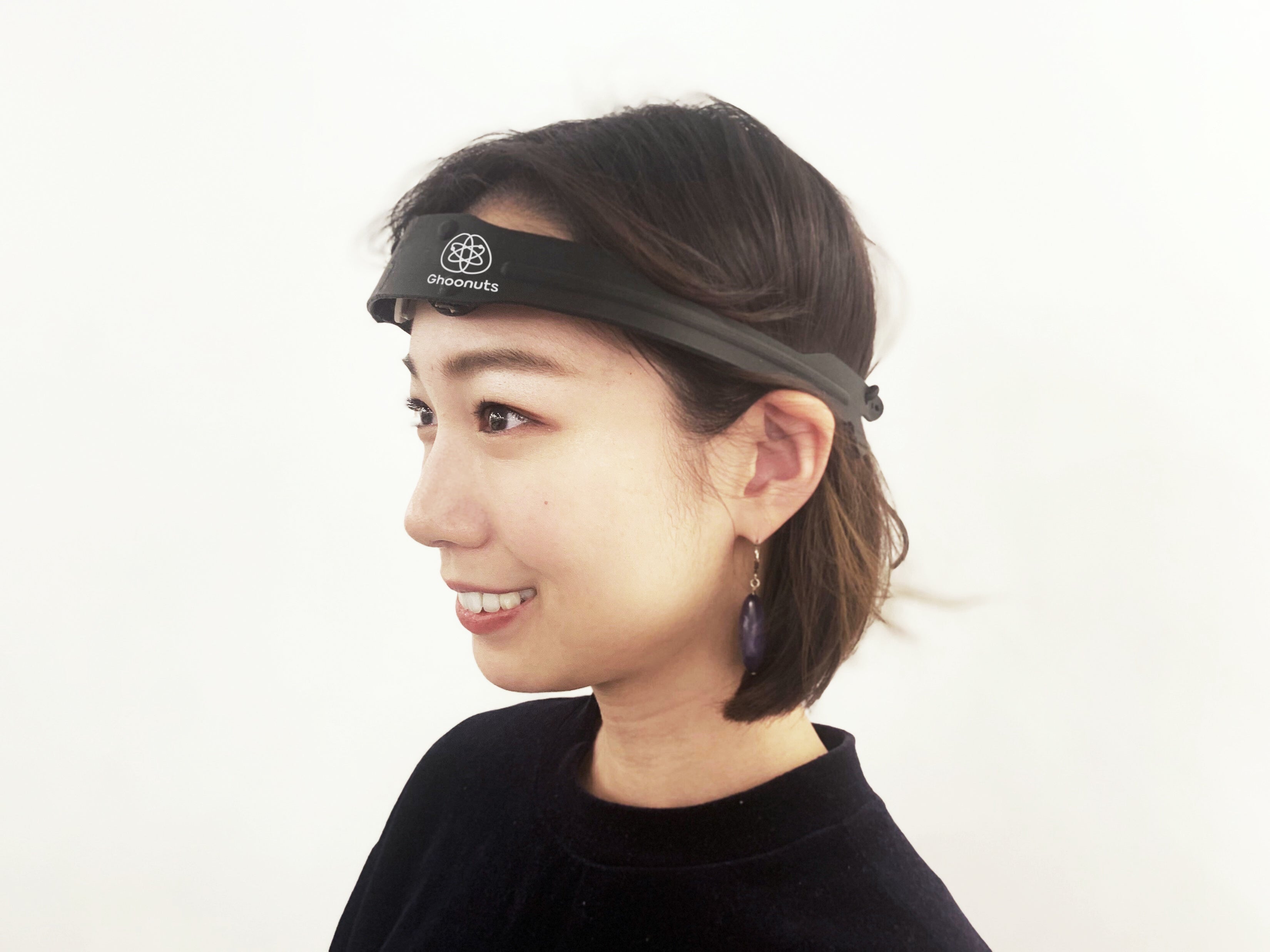 Ghoonuts独自の電気刺激をコア技術として開発したデバイスを頭に装着し電流を流している様子