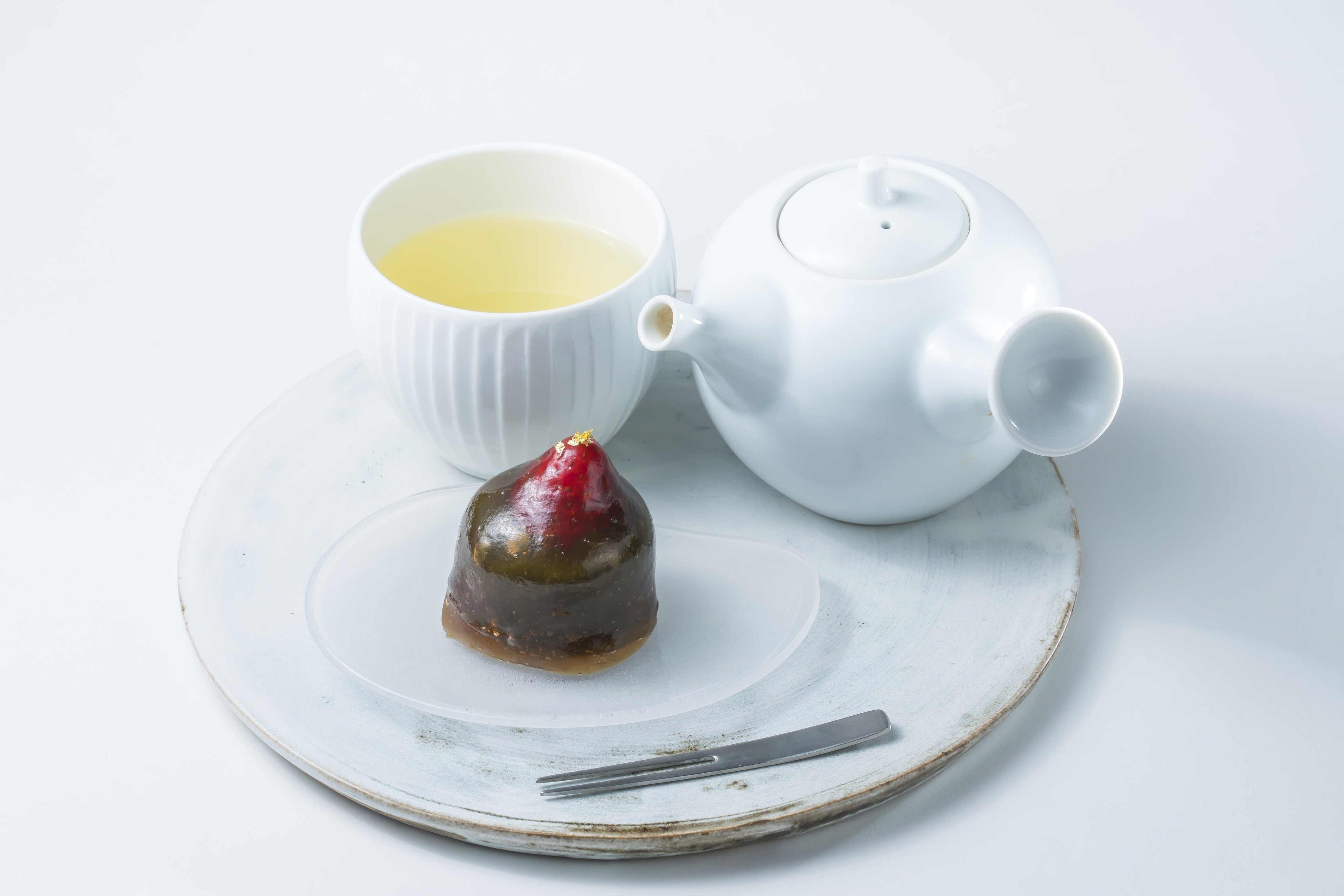 トップに金粉が飾られ、薄く苺が透ける優婉な佇まいのいちご琥珀餅(抹茶)。