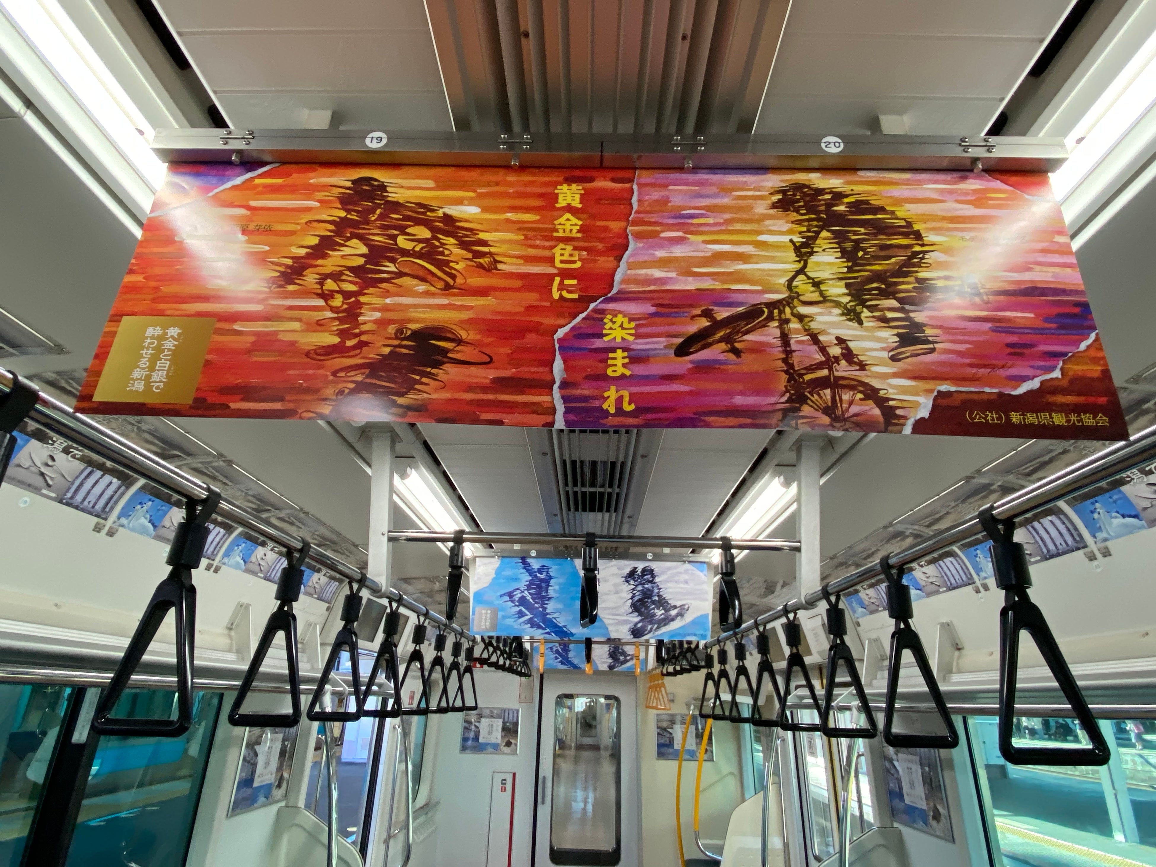 電車の外側と中吊りには「日本海に沈む夕陽の中でのスケートボード、BMX、白銀の雪山でのスノーボード」をテーマにしたアート作品が見られる