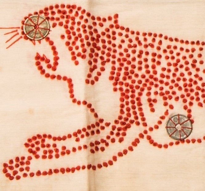 兵士コーナーの 「千人針」。トラの頭部に五銭硬貨、胸部に十銭硬貨が縫い付けられている